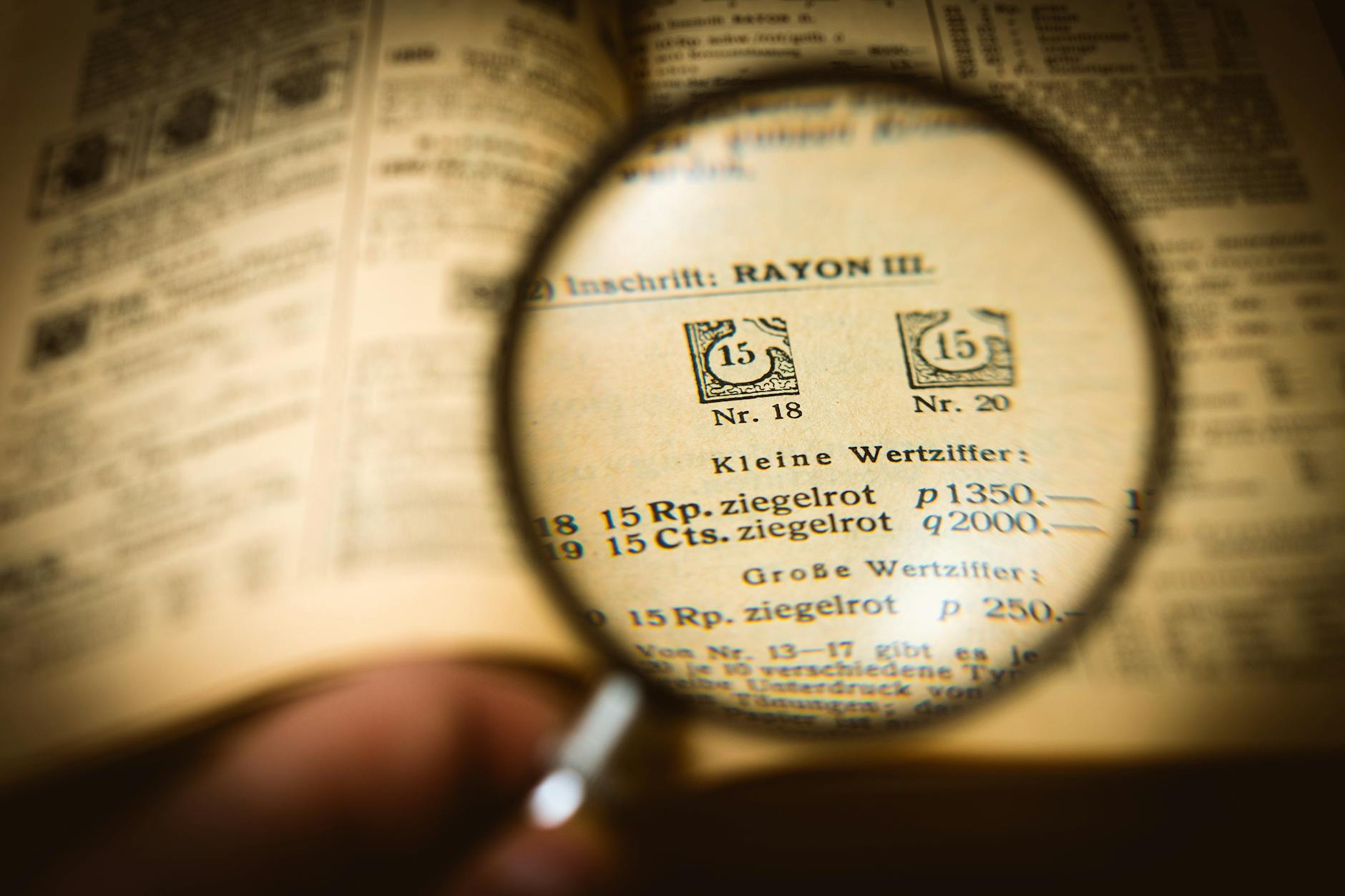 Close-up of a wooden desk with a magnifying glass resting on a stack of mystery novels and a spiral notebook.