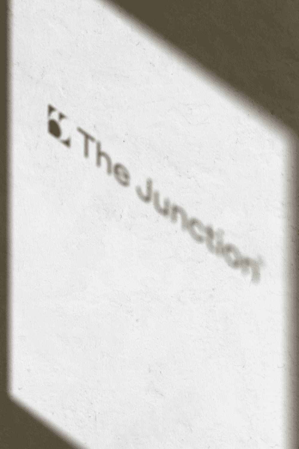 Young man in a formal outfit with a striped shirt, grey tie, and black coat. The tone is serious and professional, emphasizing subdued elegance.