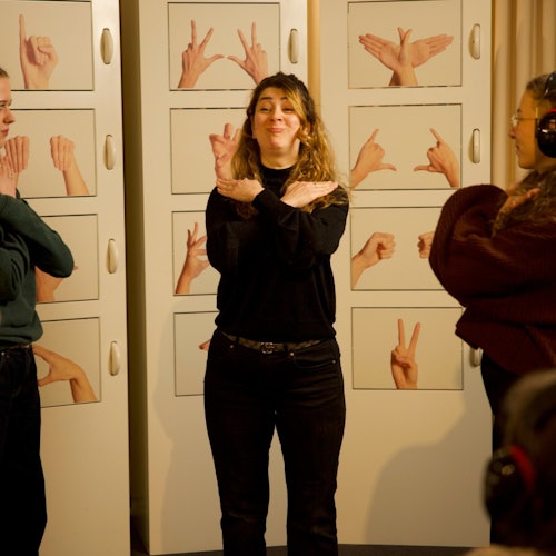 Guests try to interpret the gestures of a deaf guide.