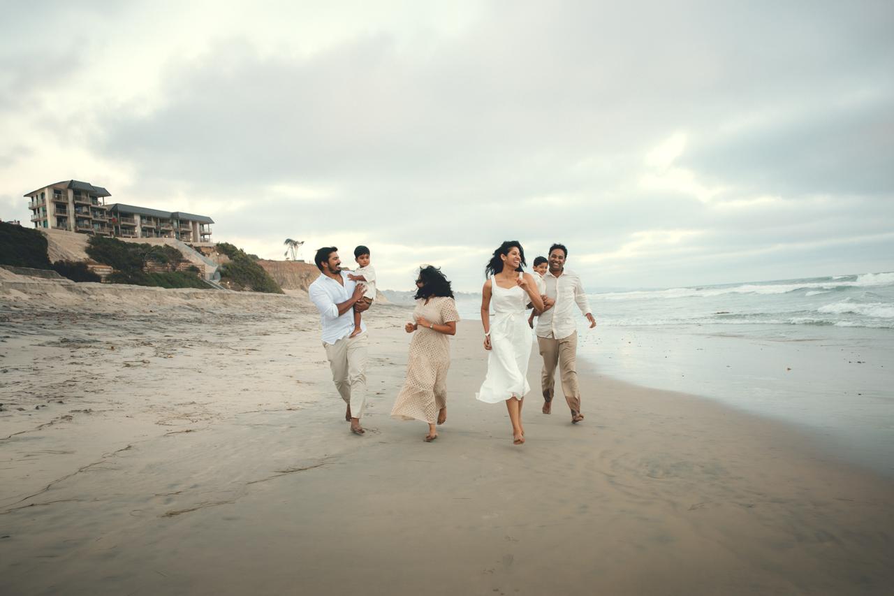 Multi-generational family walking along the San Diego coastline together at sunset