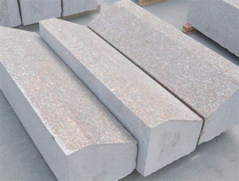 Large trapezoidal granite blocks with a rough finish, arranged in parallel lines. These stones are designed for construction or landscape use.