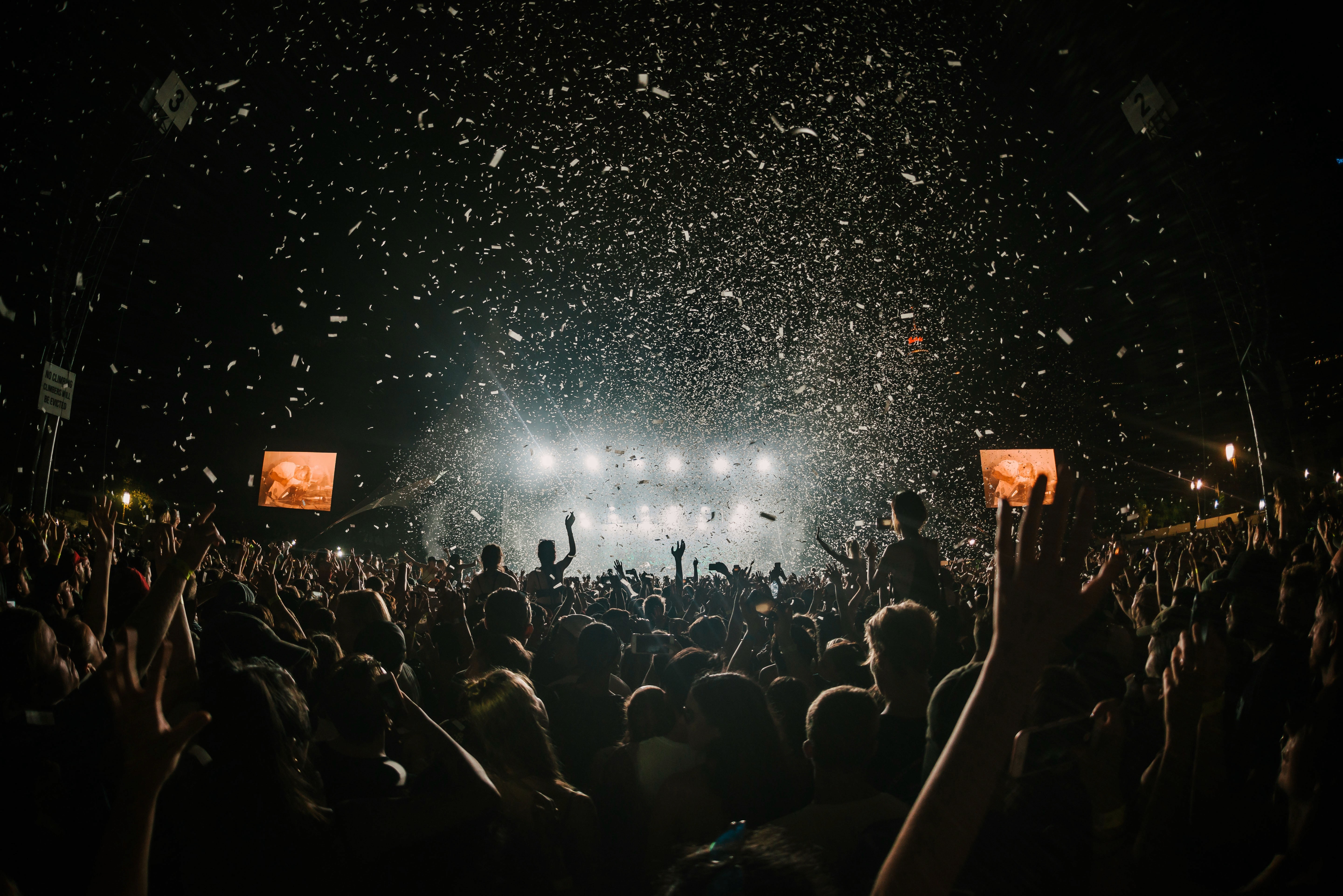 Large crowd of people with confetti flying in the air for generative music concert