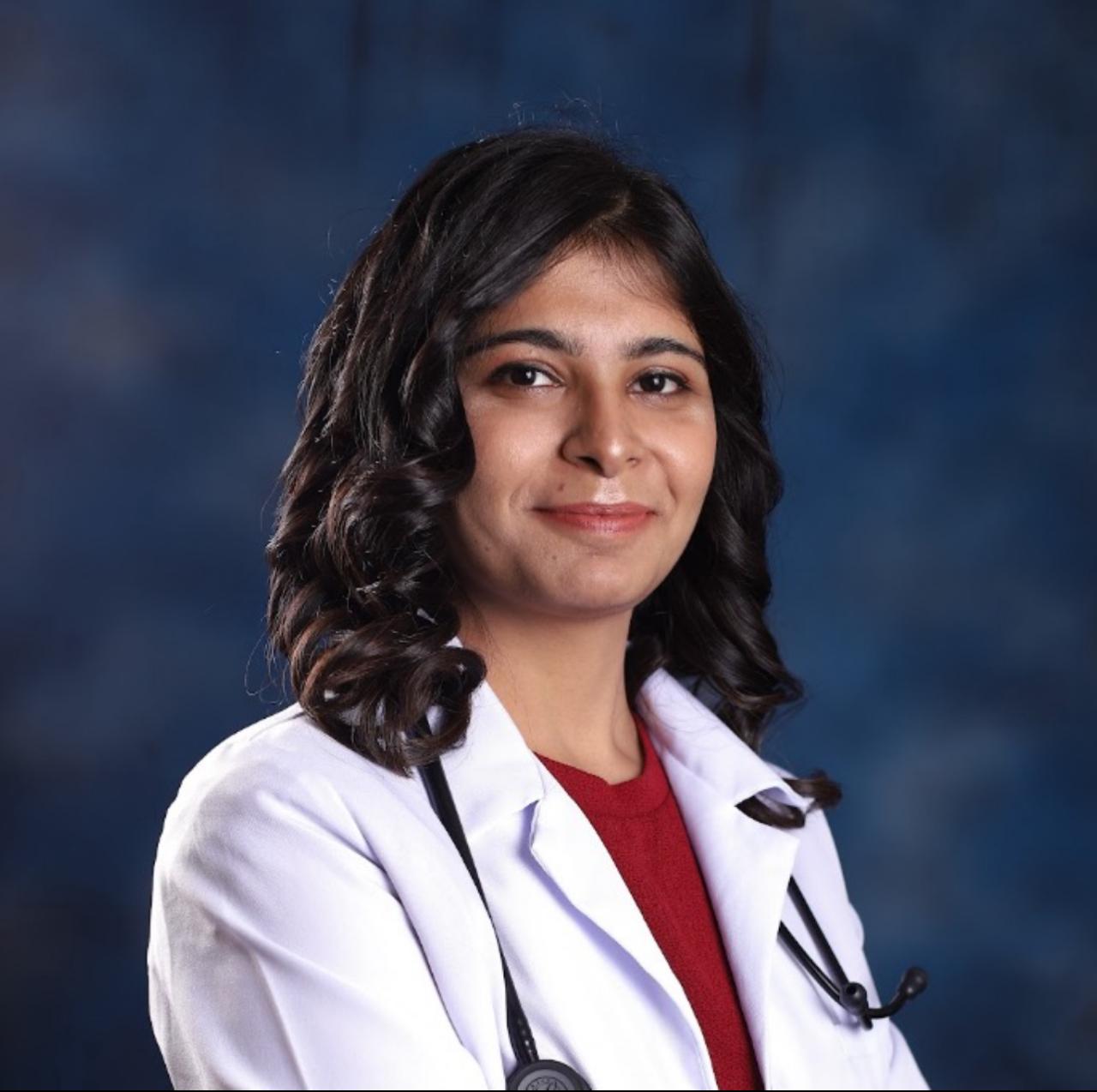 A businesswoman sitting at her desk, smiling and looking at the camera.