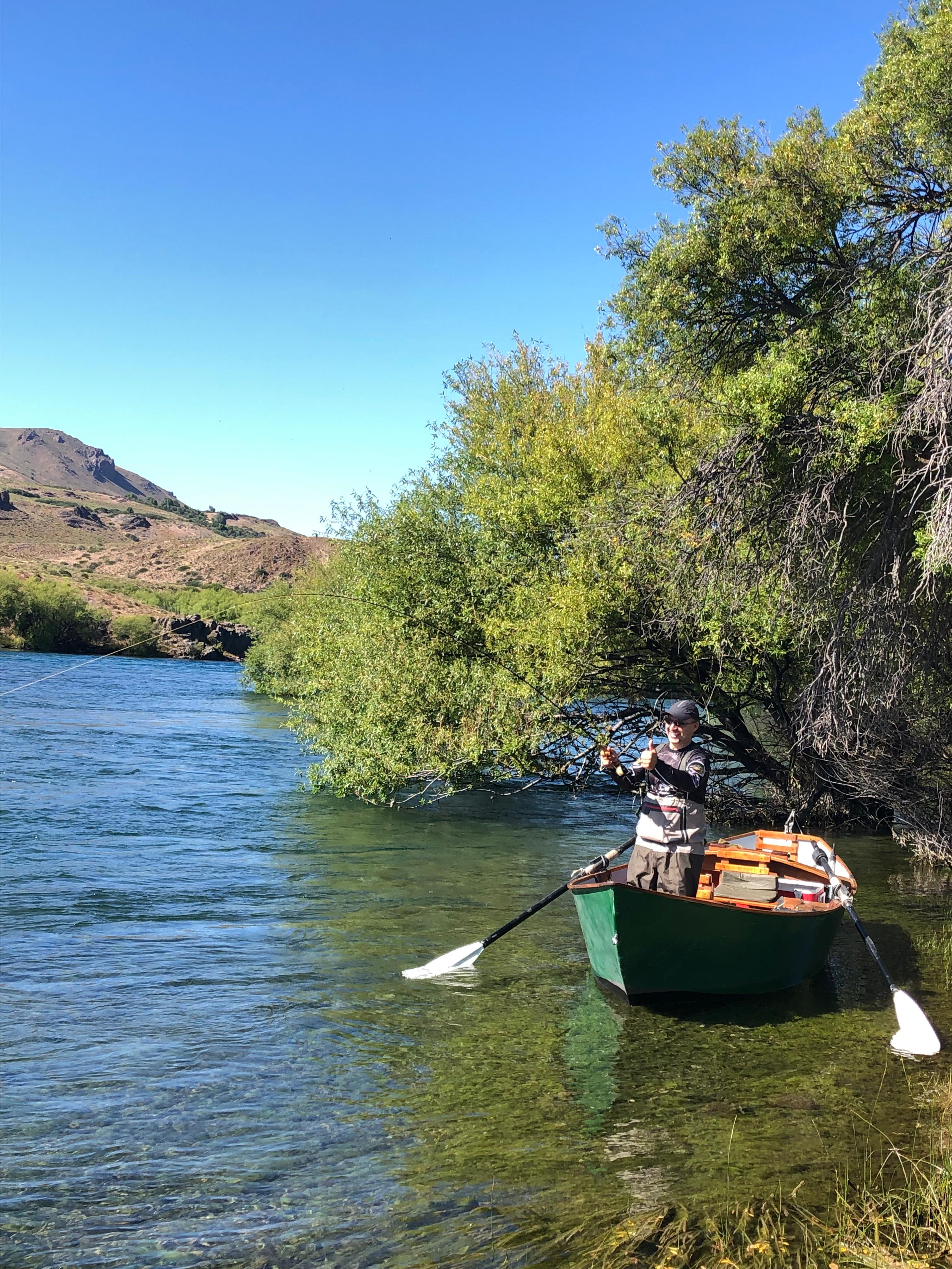 Angler fly fishing on the Limay River, Patagonia, for giant trout using streamers and rowboats.