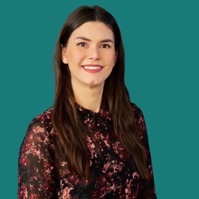 A person wearing the grey coat smiling in a cozy sunlight