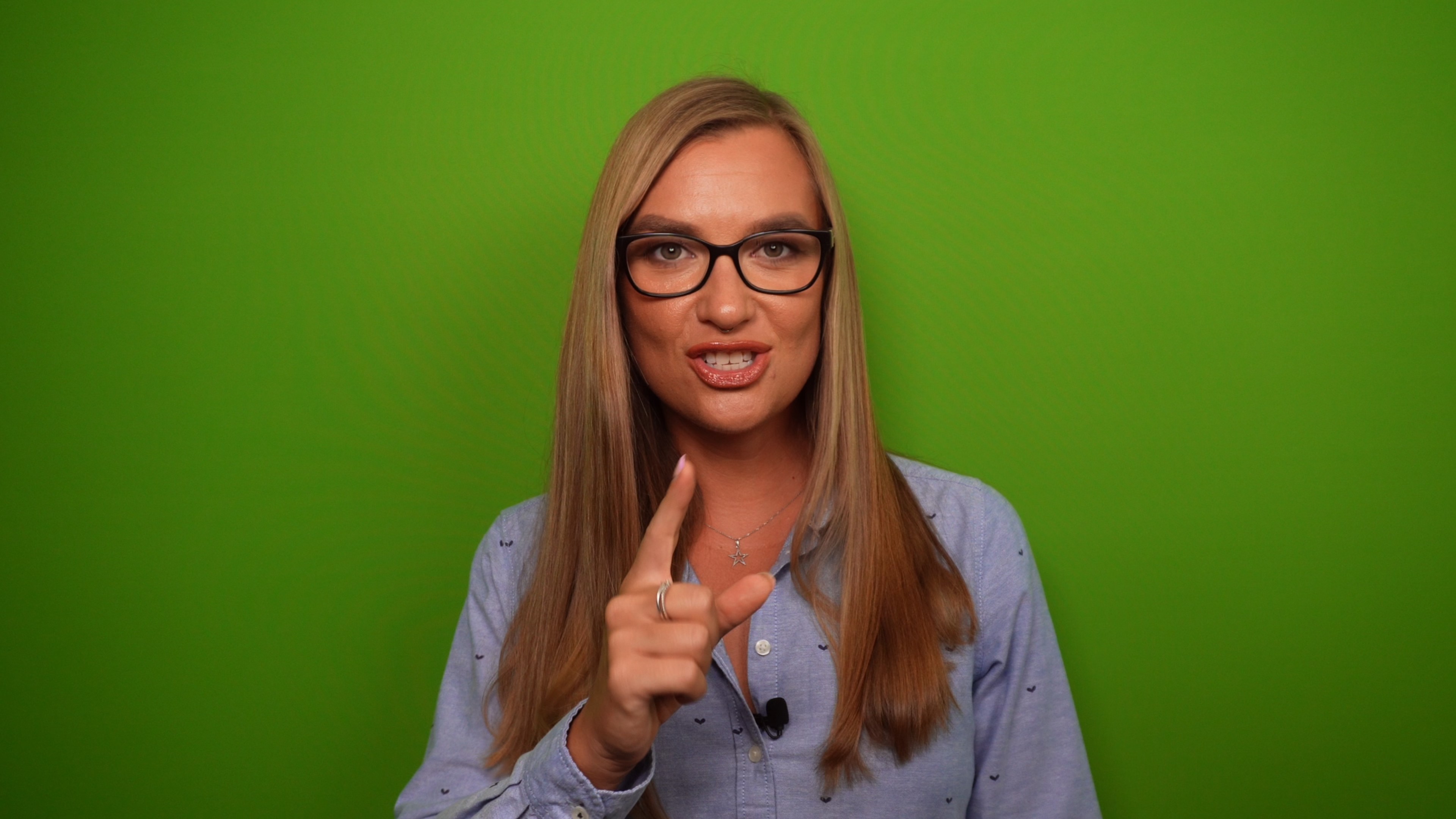 Woman stood against a green screen