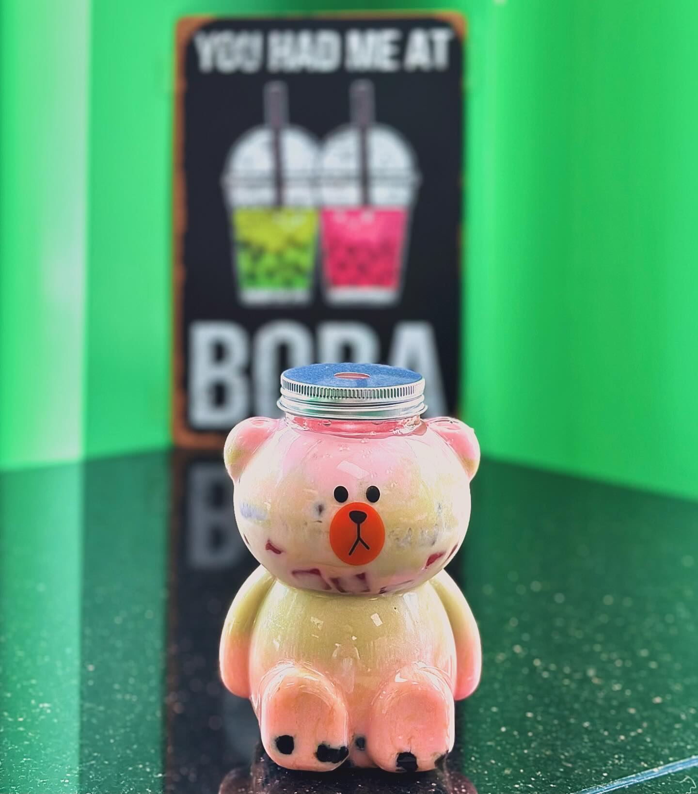 Adorable bear-shaped bubble tea cup filled with a fruity drink from Lil M Bubble Tea, a unique and playful way to enjoy your favorite boba.