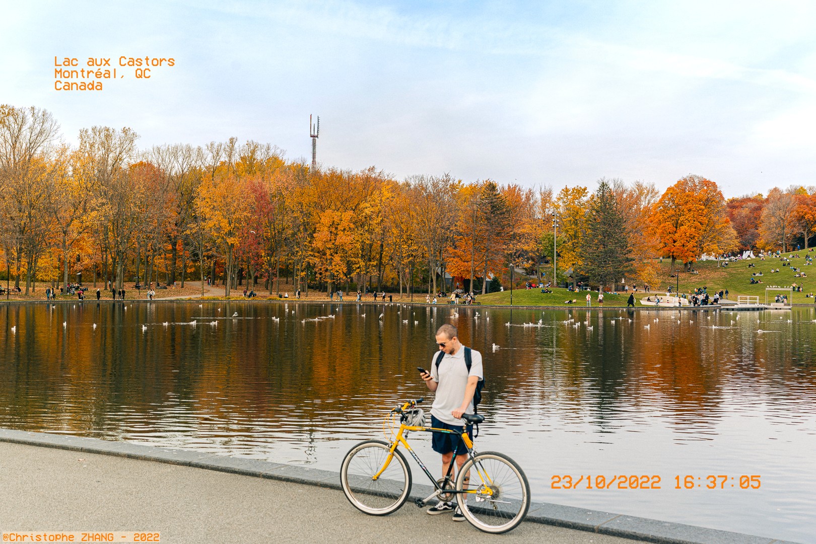 Cycliste prenant une pause au bord du lac aux Castors en automne à Montréal.