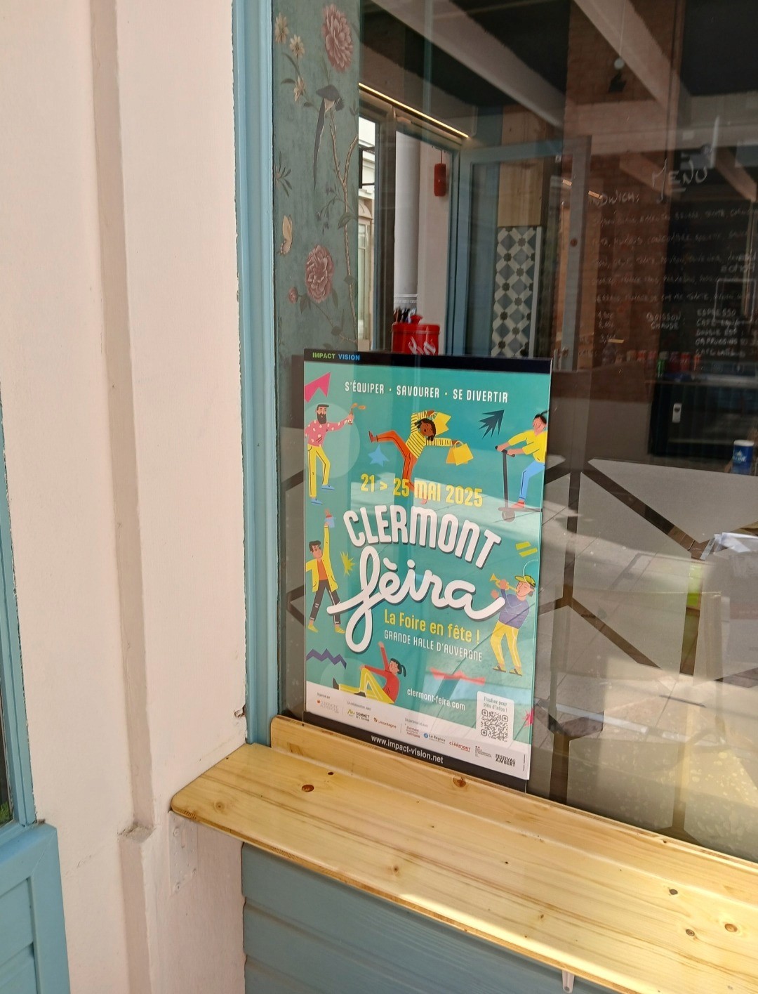 Porte affiche Impact vision sur une vitrine de magasin