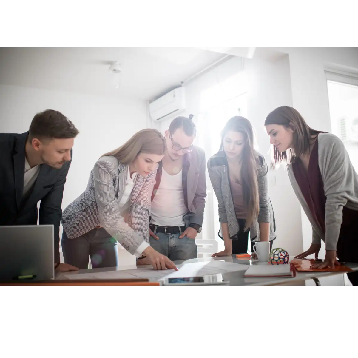 un groupe de personne autour d'un plan sur une table