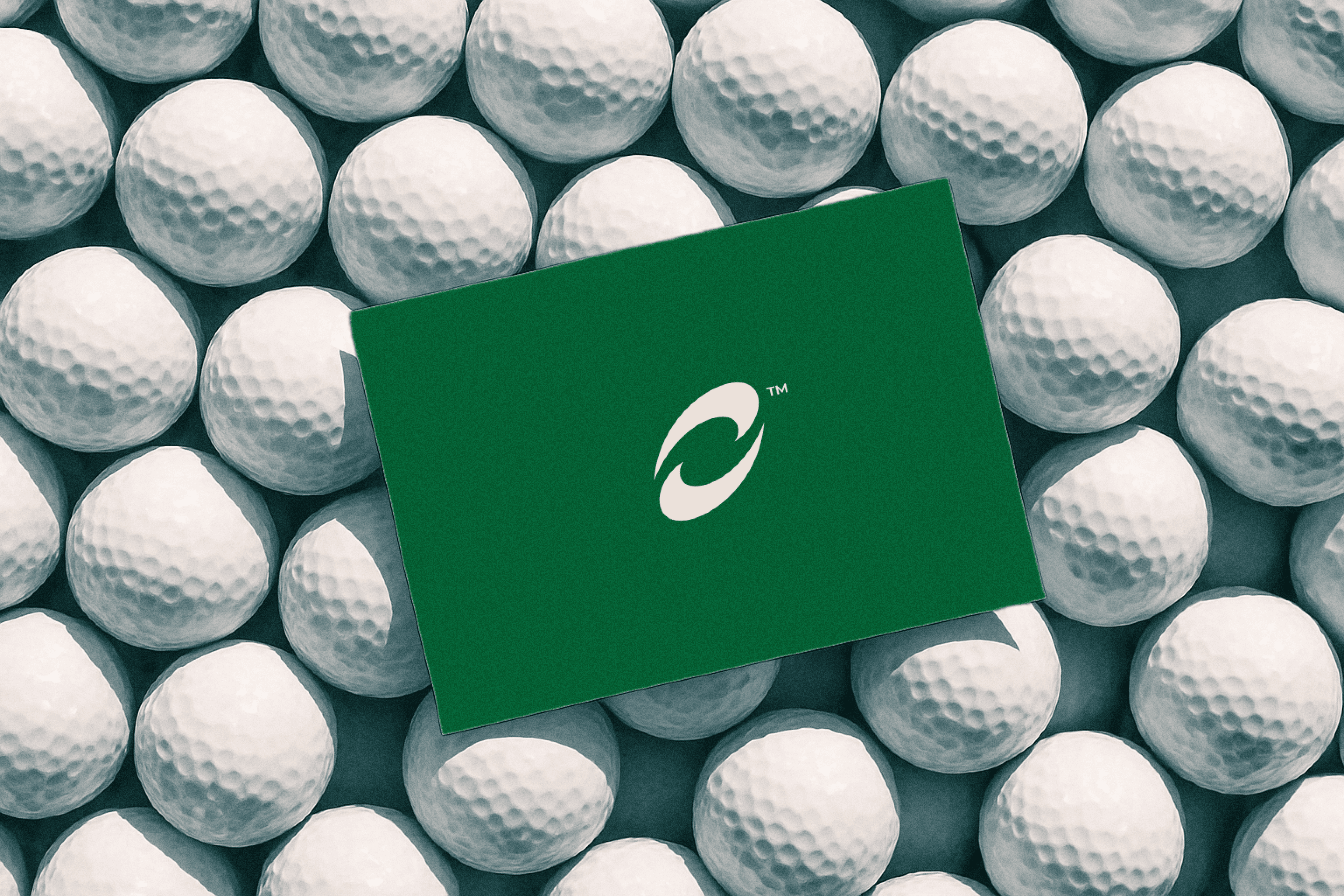 Green card with a white logo placed on top of a pile of white golf balls.