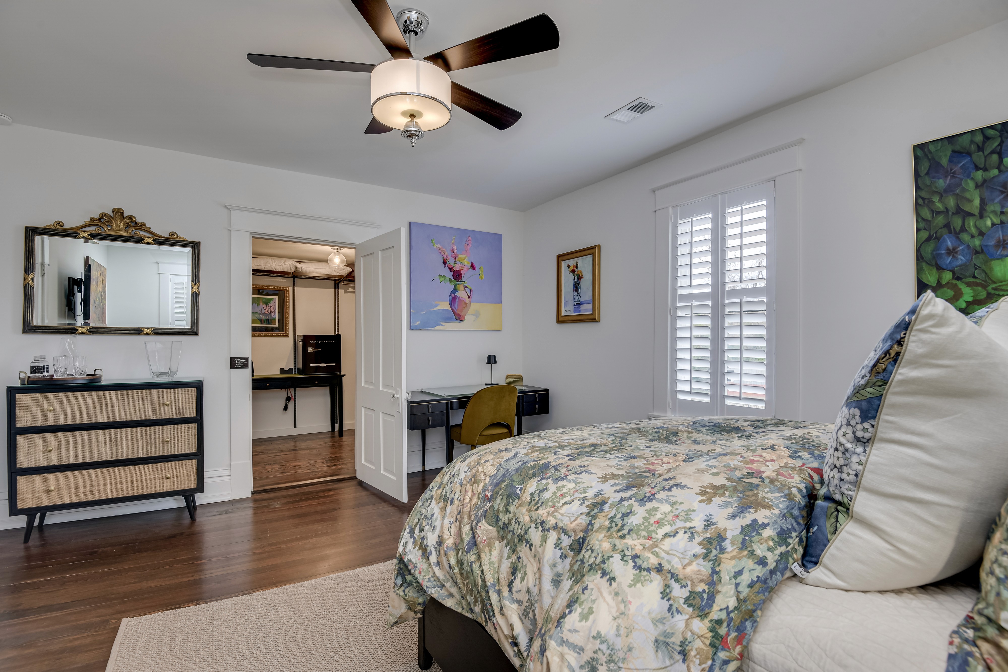 Generously sized bedroom featuring a queen-size bed and a dedicated workspace.