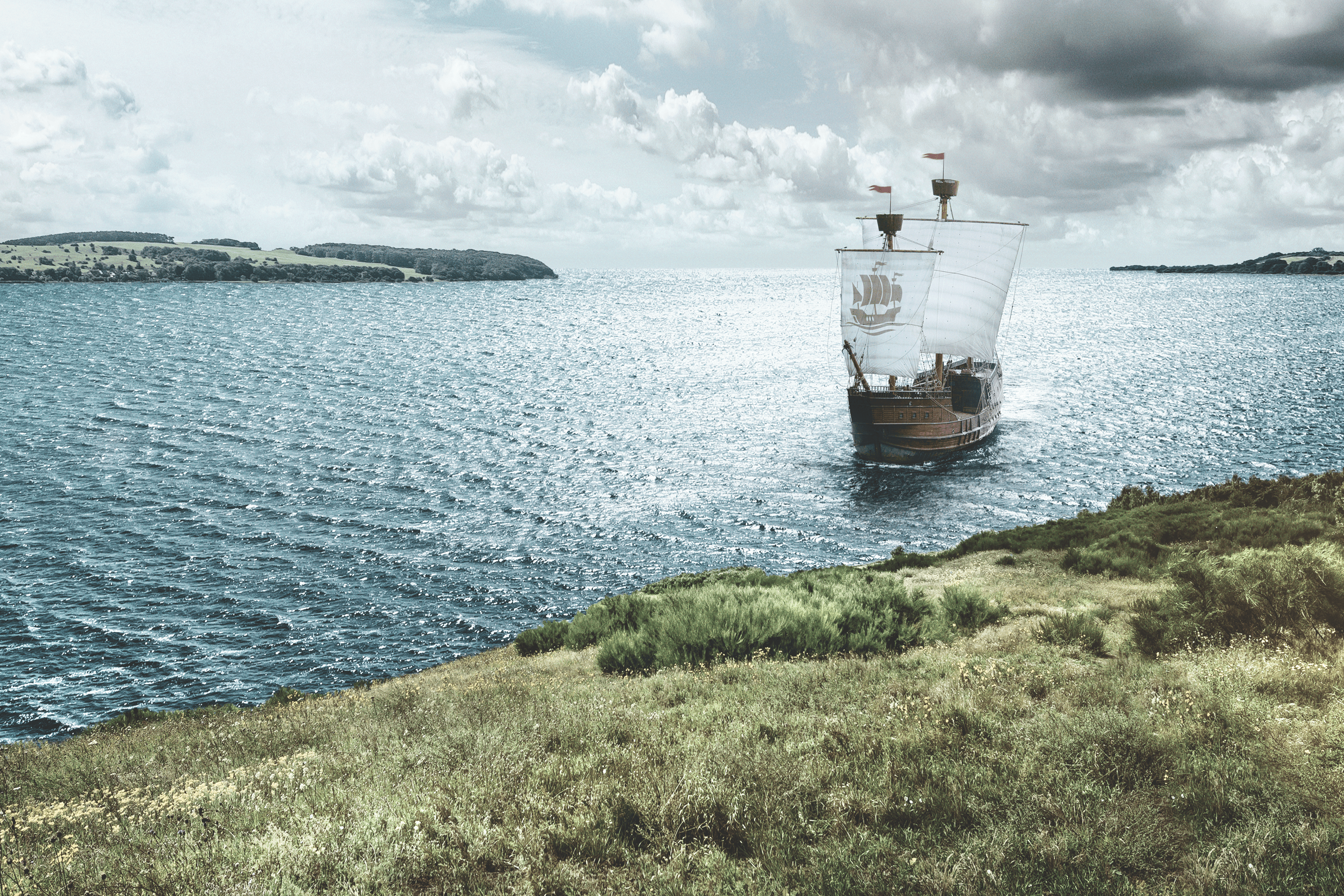 Galleon sailing on the sea near a grassy island.