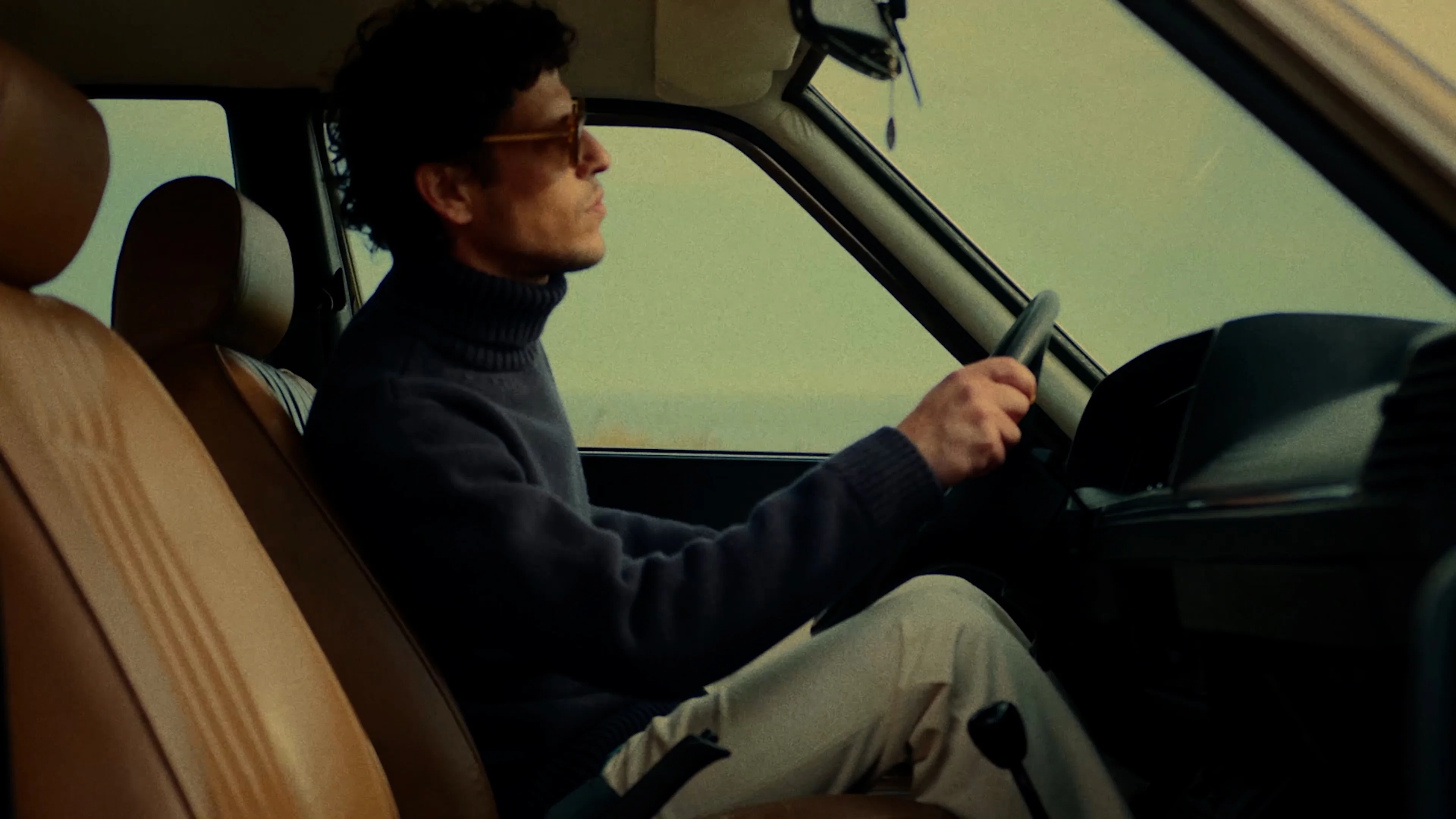 un homme asphalte au volant de sa voiture