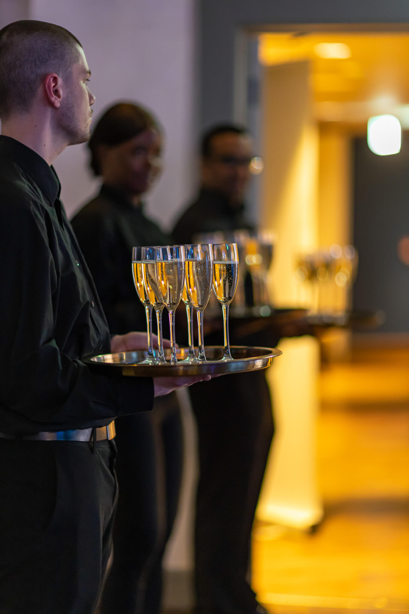 Waiter holding a tray of champagne glasses during an evening reception