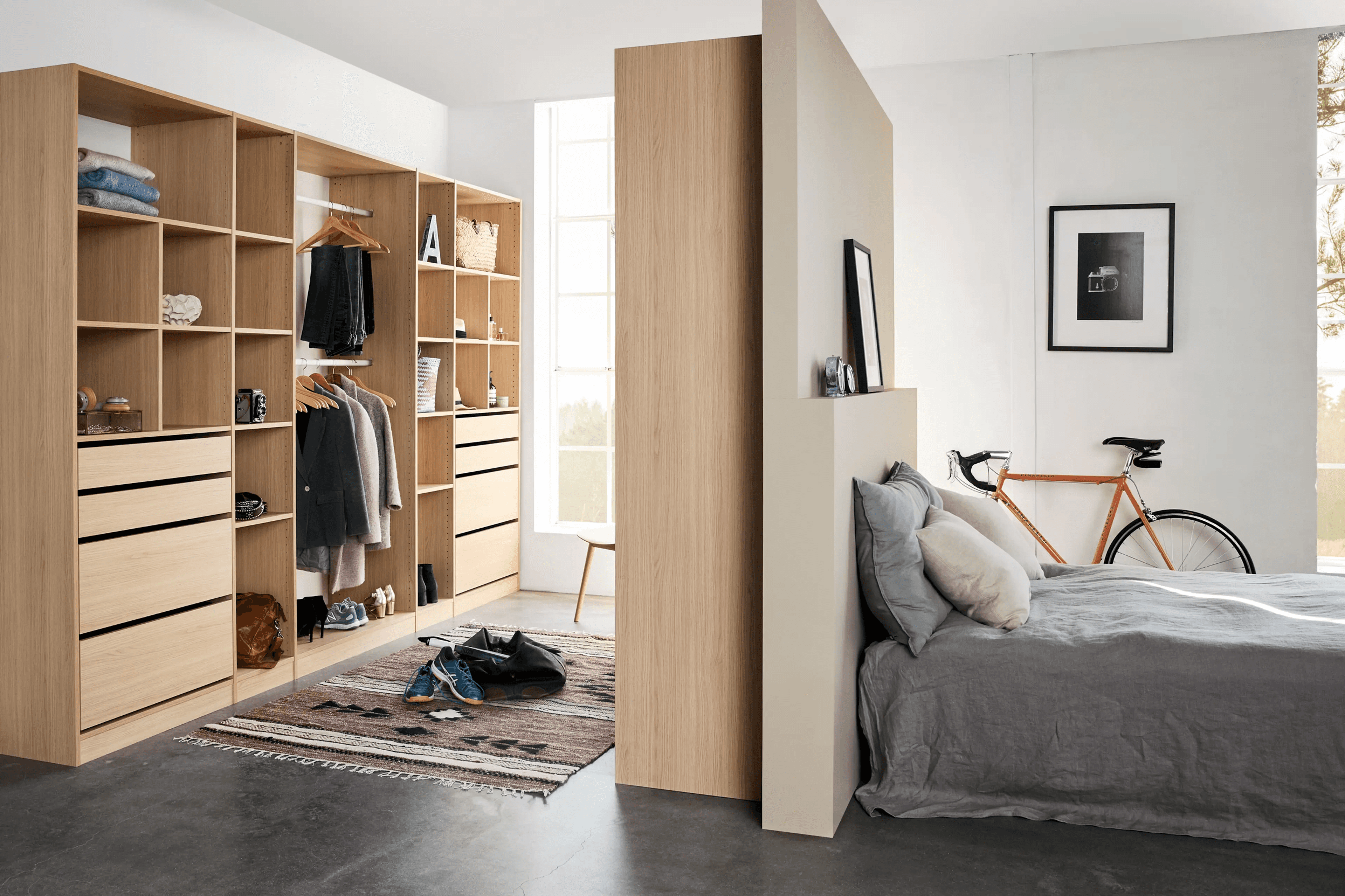 가벽으로 깔끔하게 분리된 아늑한 침실과 그 뒤 드레스룸 입구 사진