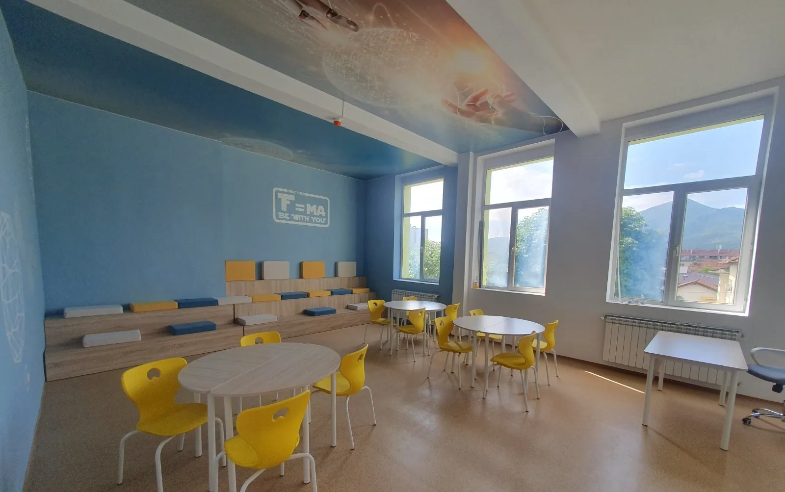 Modern classroom with yellow school chairs and round tables