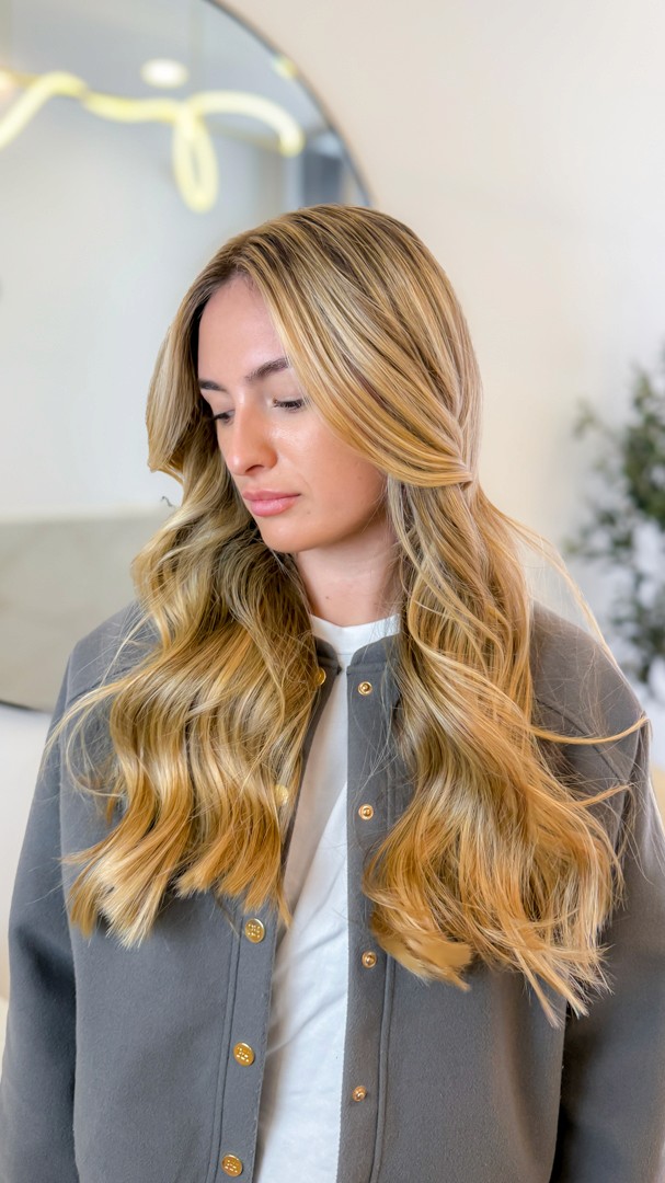 A close-up of hands performing a relaxing massage, with warm golden light illuminating the skin. The scene evokes a sense of relaxation and well-being.