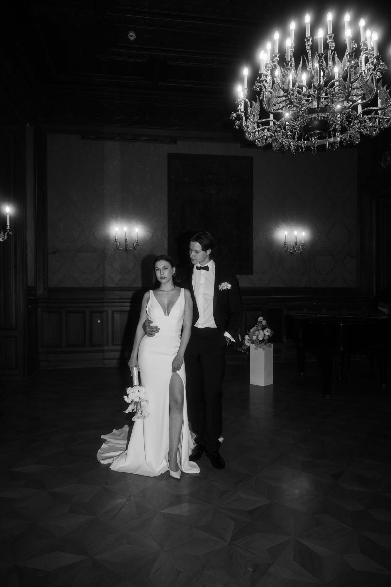 Brautpaar steht lässig mitten in einem Ballsaal in Wien.