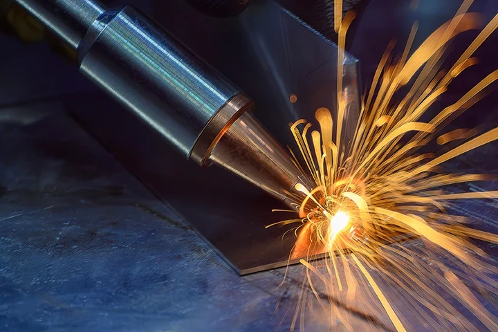 Laser welding process joining steel components, with a focused welding head producing sparks during precision fabrication.