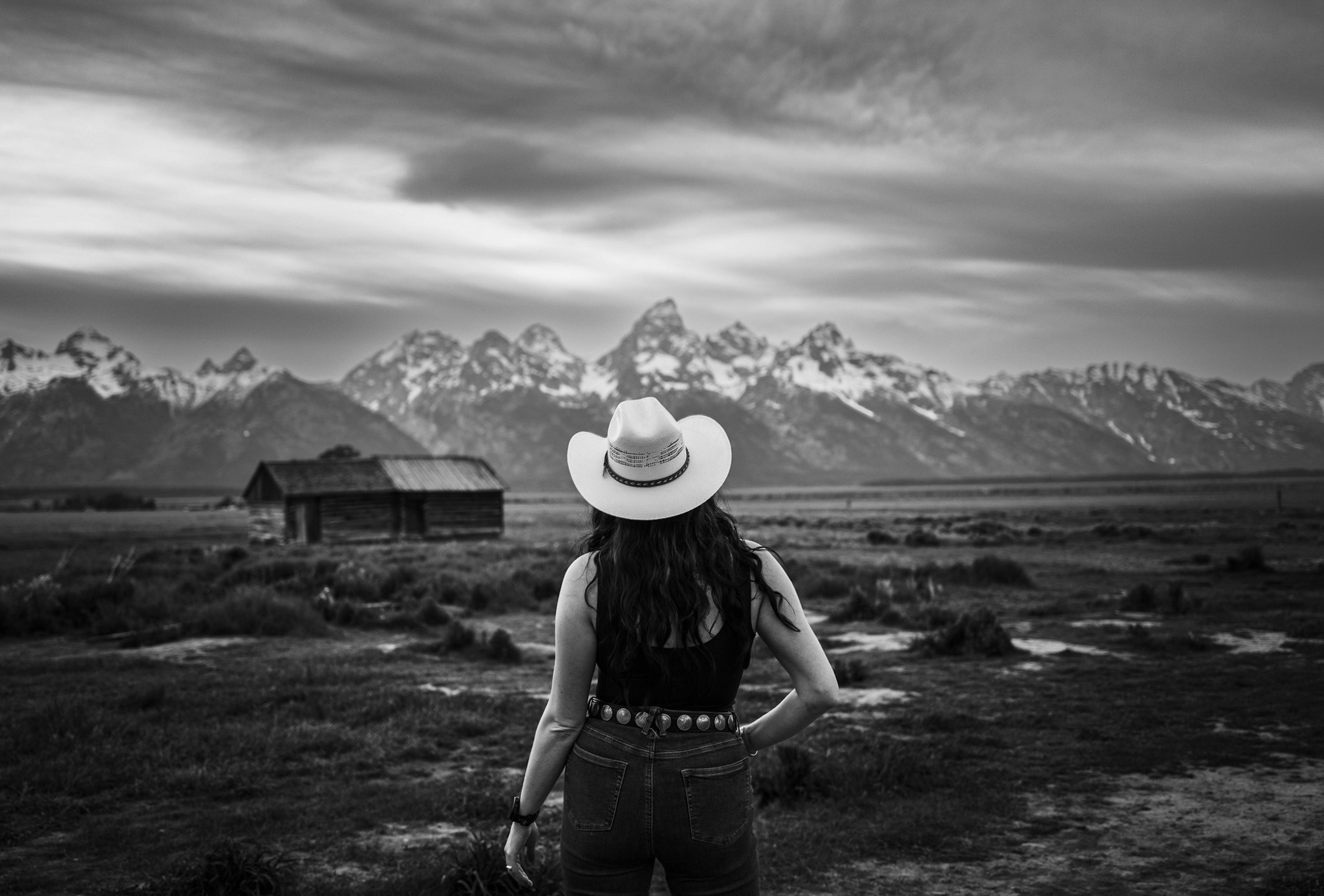 The sun peaking through a rocky arch formation at sunset