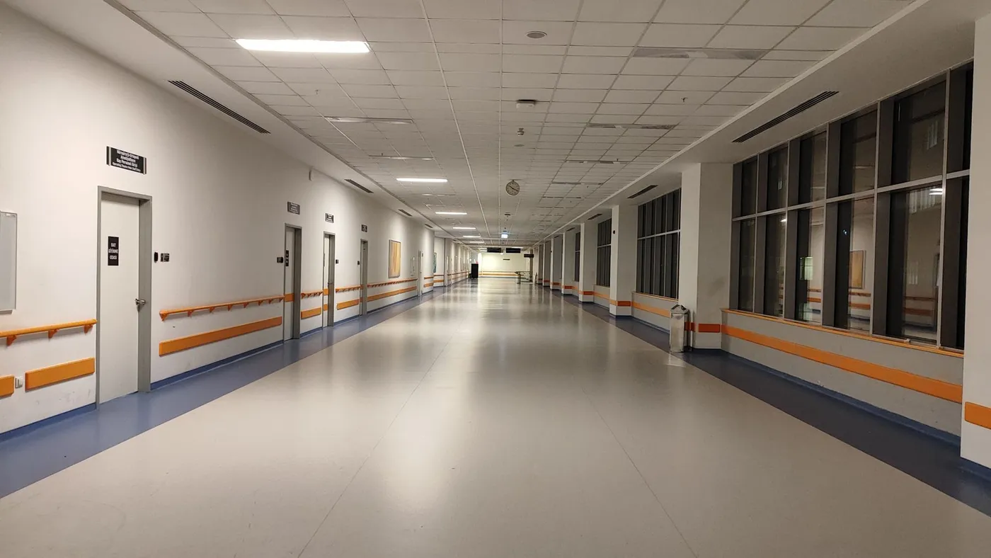 A long, bright corridor in a modern hospital