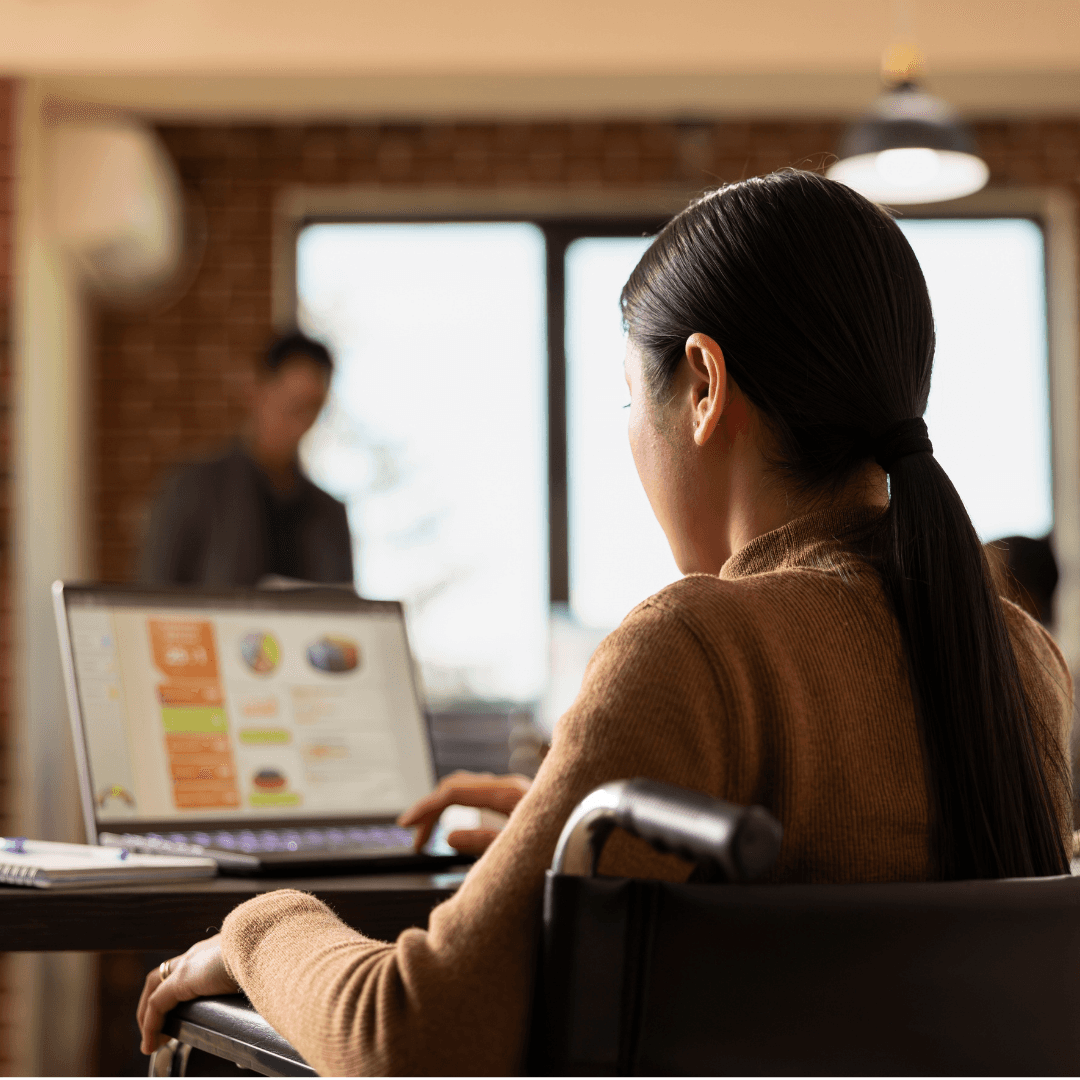 Lady on wheelchair looking at a digital platform on her laptop