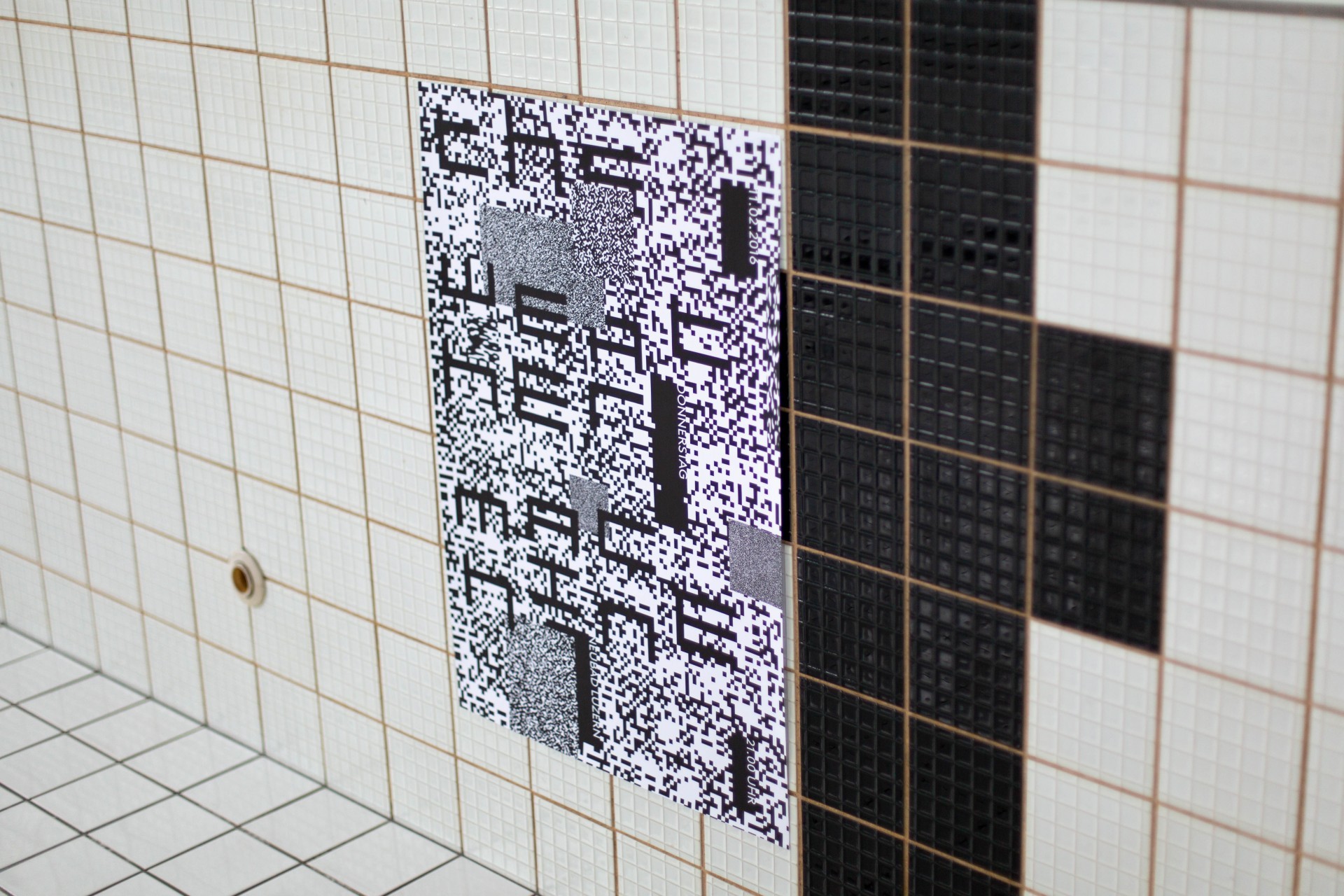 A poster hanging in the Neubad pool featuring noisy, pixelated patterns with big typography in black and white.