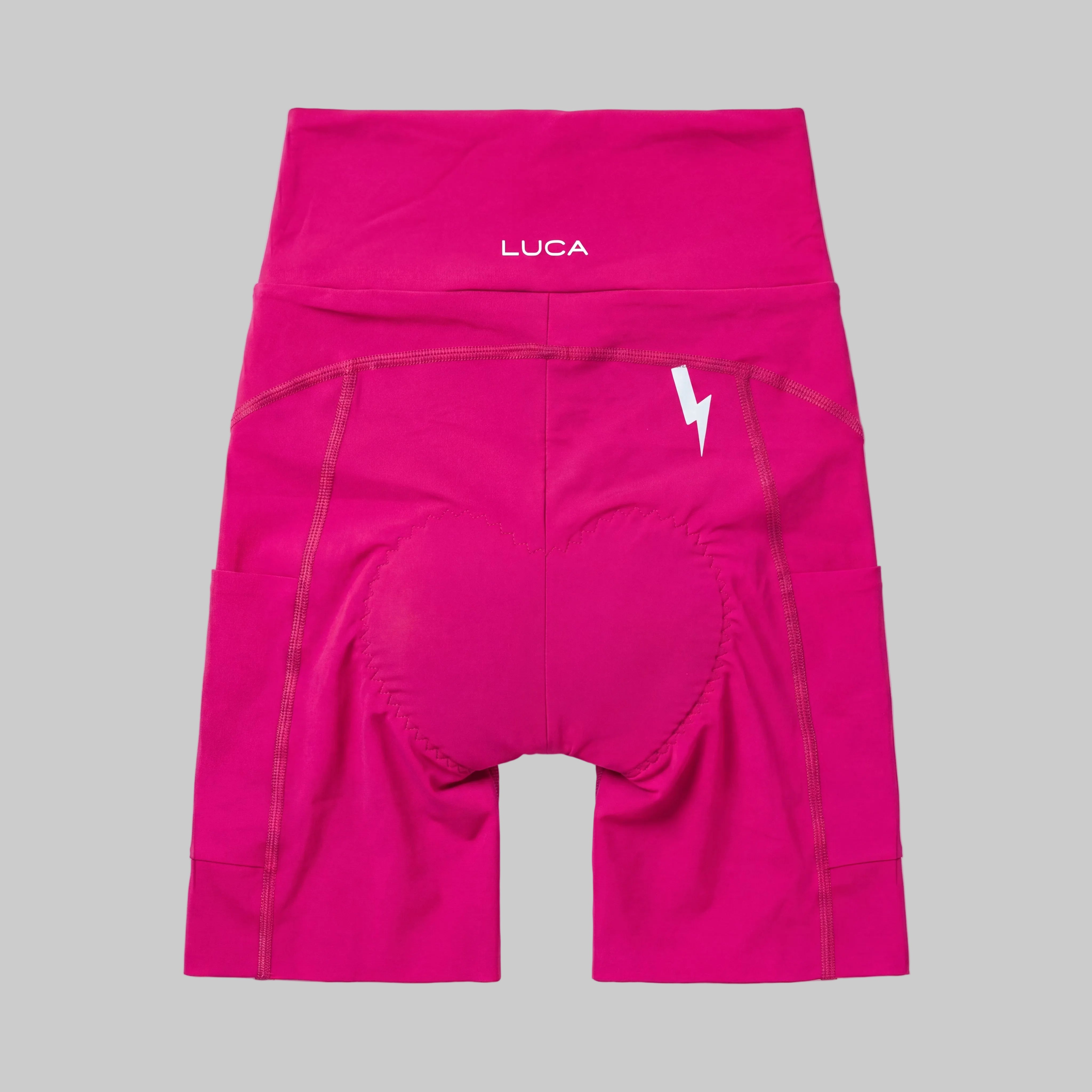 LUCA Empower women's high-waisted cycling shorts in hibiscus, back view with chamois and bolt detail