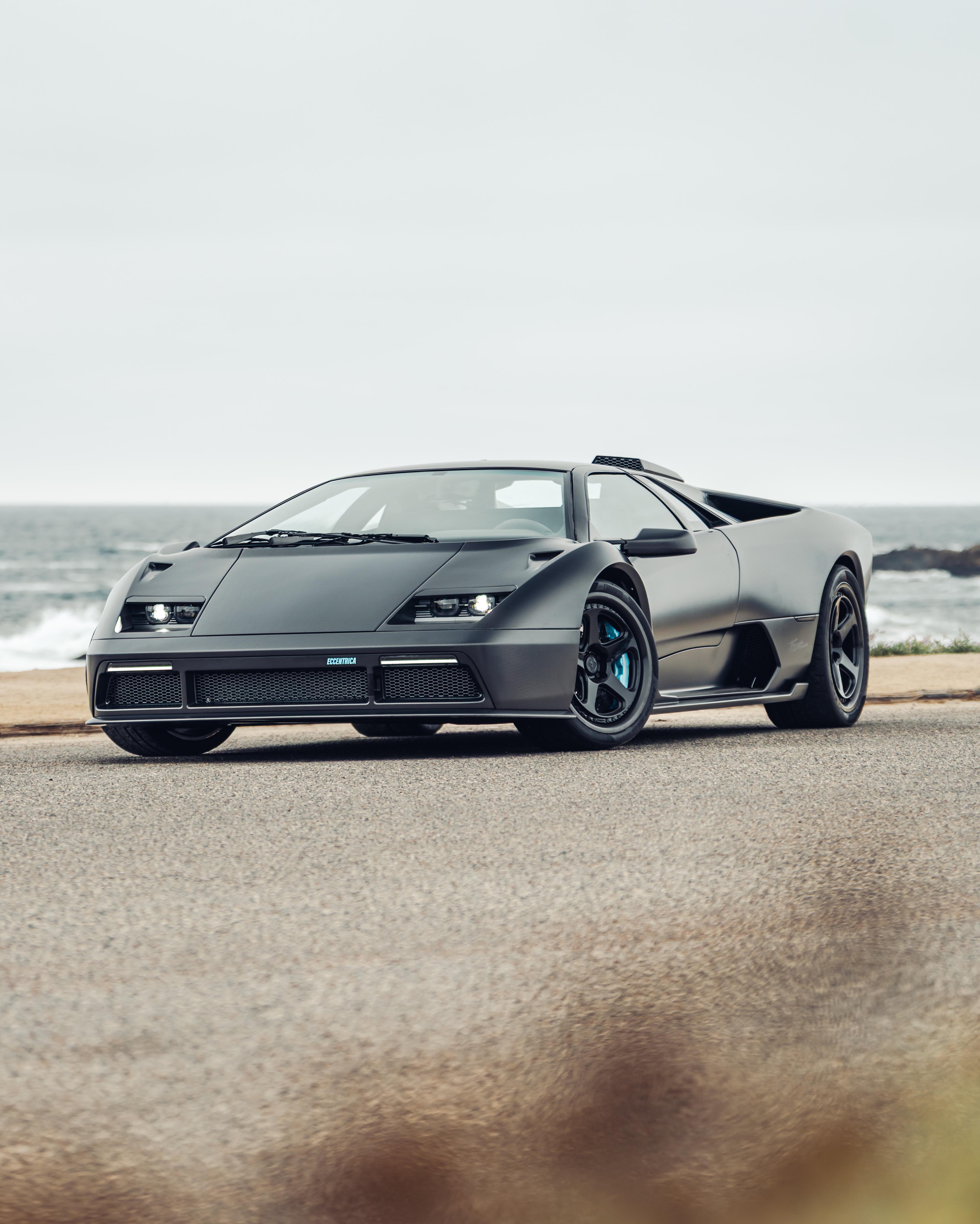 Foto lfrontale di auto sportiva nera vicino al mare