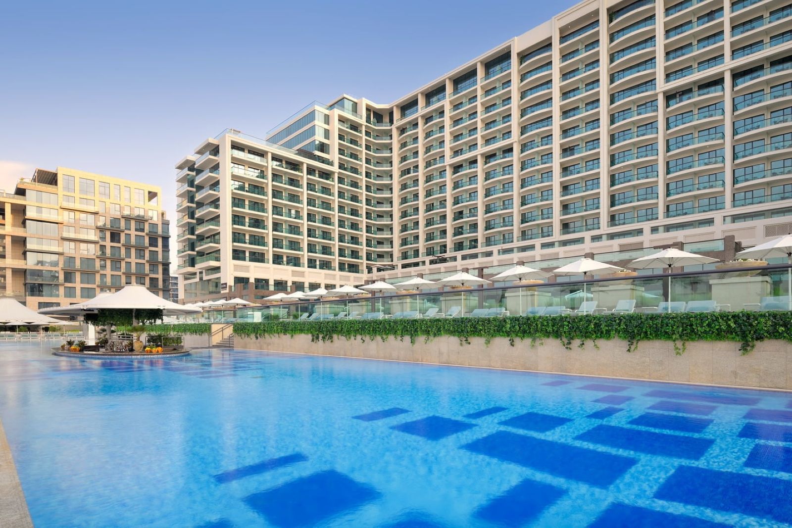 The outdoor pool of Marriott Resort Palm Jumeirah with a view of the main building in the background.
