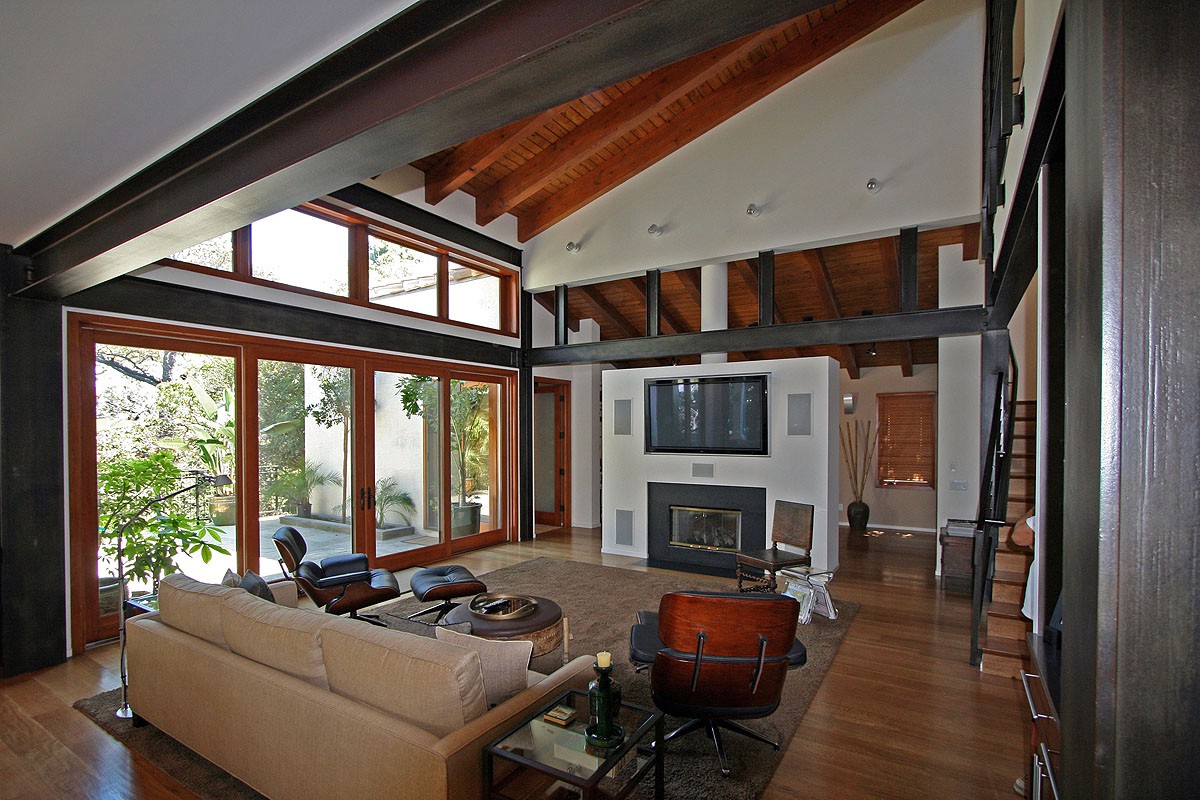 Living room with stairs and exposed beams, showcasing the open space and architectural details that blend rustic and contemporary styles.