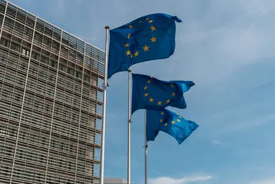 Banderas de la UE ondeando frente a un edificio moderno