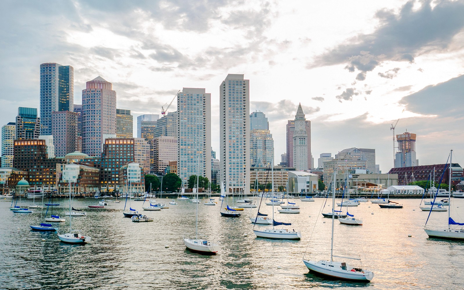 Boston Harbor with sailboats and city skyline in the background.