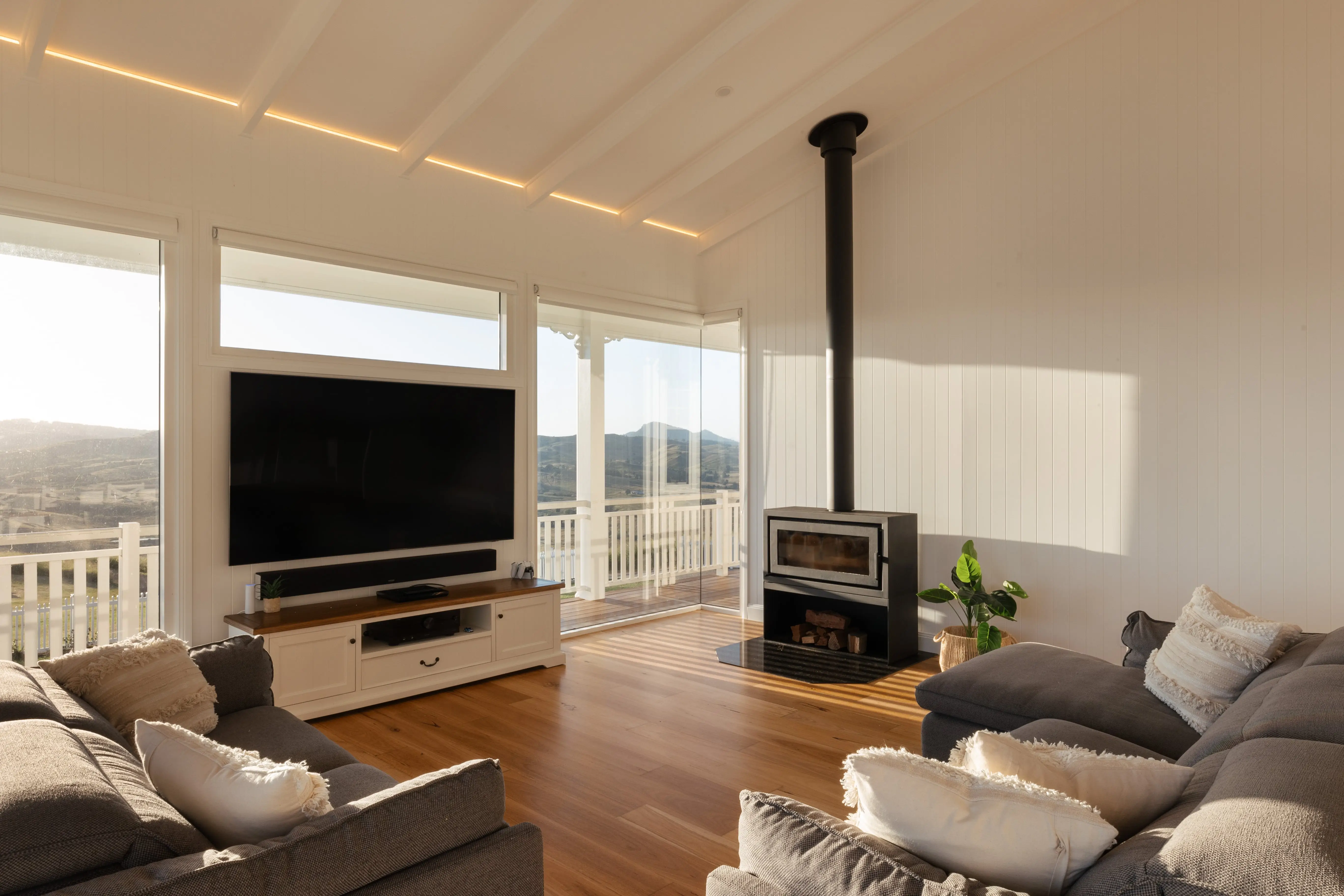 A living room with sunlight streaming in with a fireplace on the right hand side