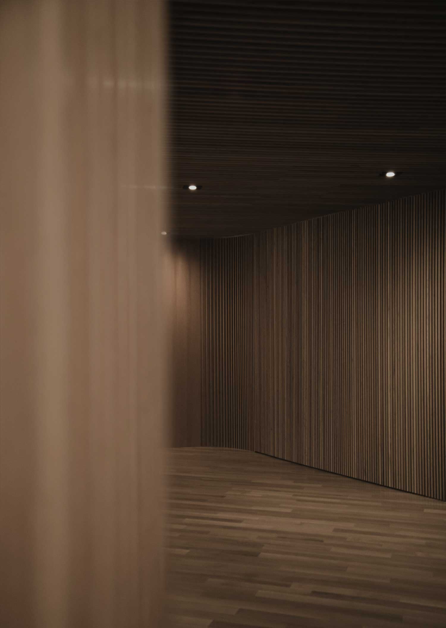 Interior of a modern room with wooden slatted walls and floor, illuminated by recessed ceiling lights.