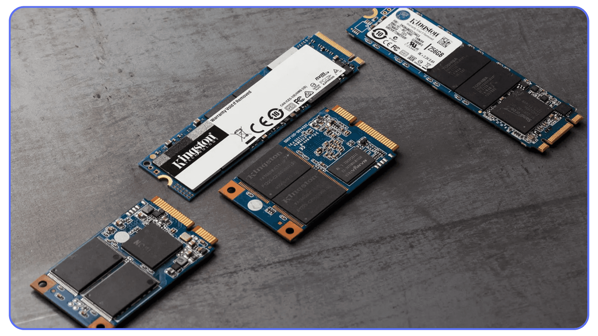 Assorted M.2 and SATA SSD storage drives laid out on a gray surface.