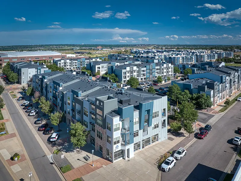 Aerial view of a sprawling modern residential apartment complex with multiple buildings featuring grey and blue facades, representing a large-scale construction project protected by M-Fire suppression technology.