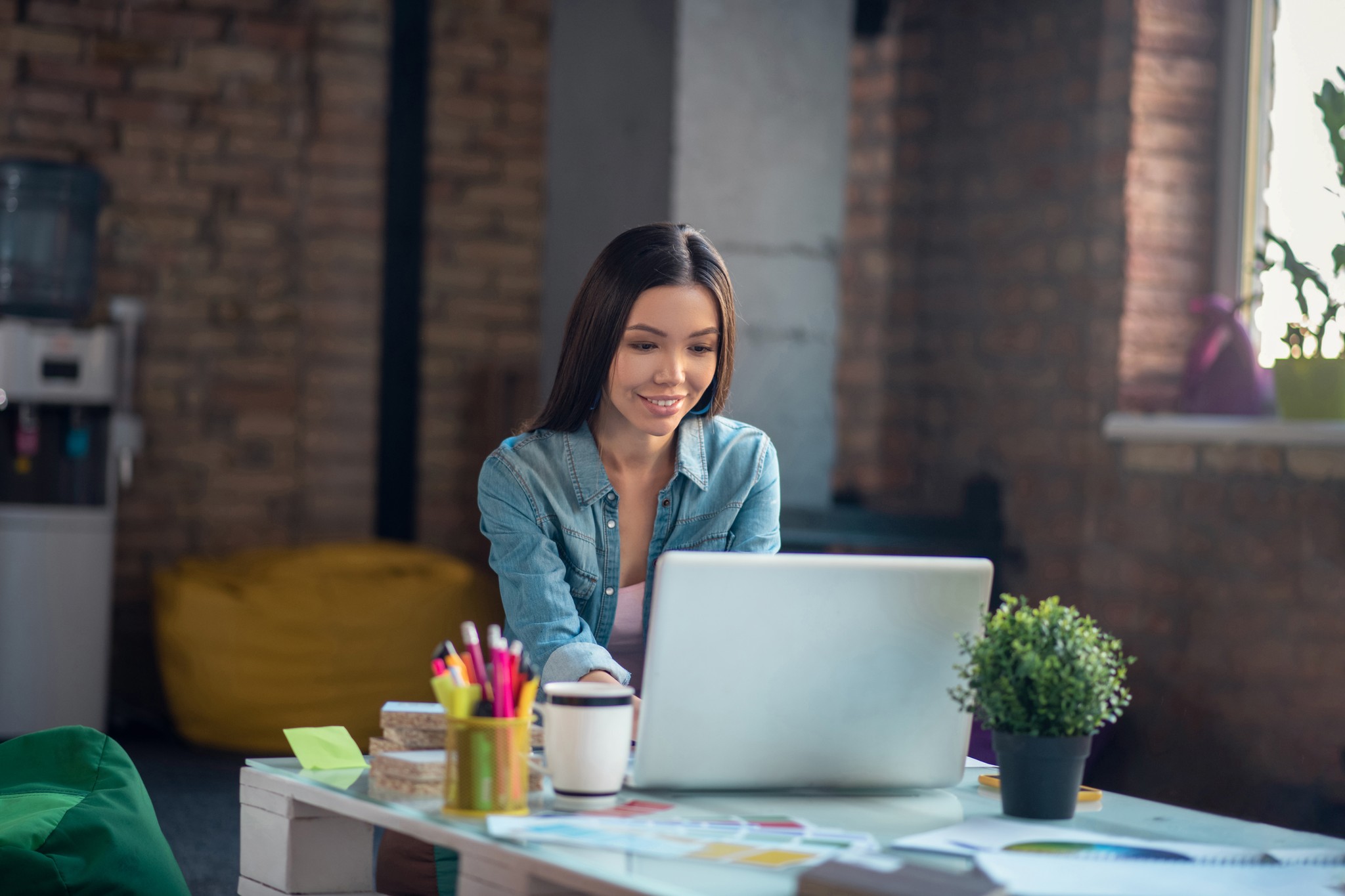 Woman working on laptop in creative office space
