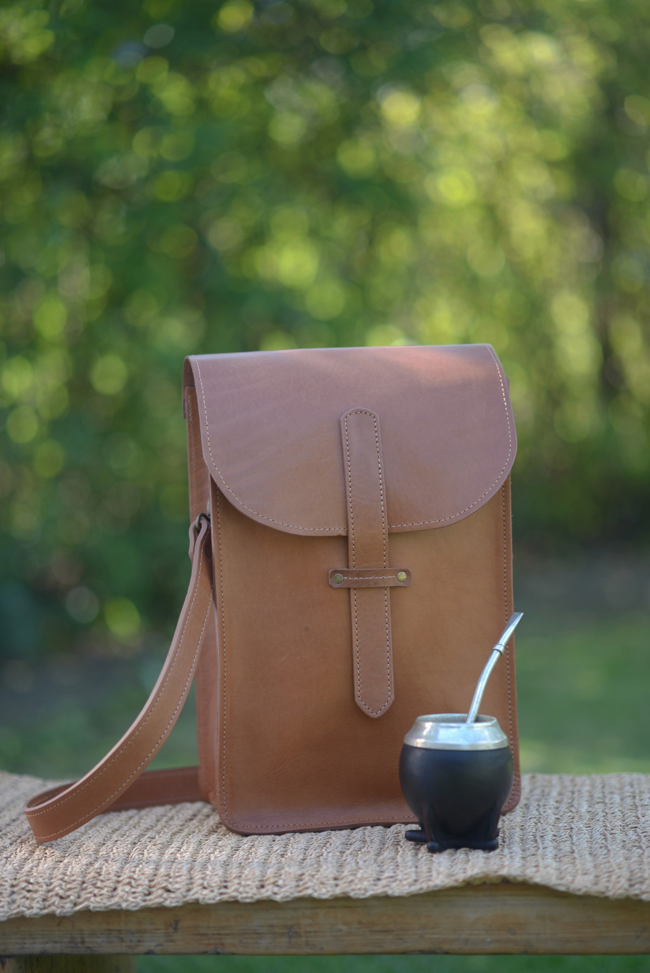 A smiling young man with crossed arms, wearing a plaid shirt and white t-shirt, poses against a dark background.