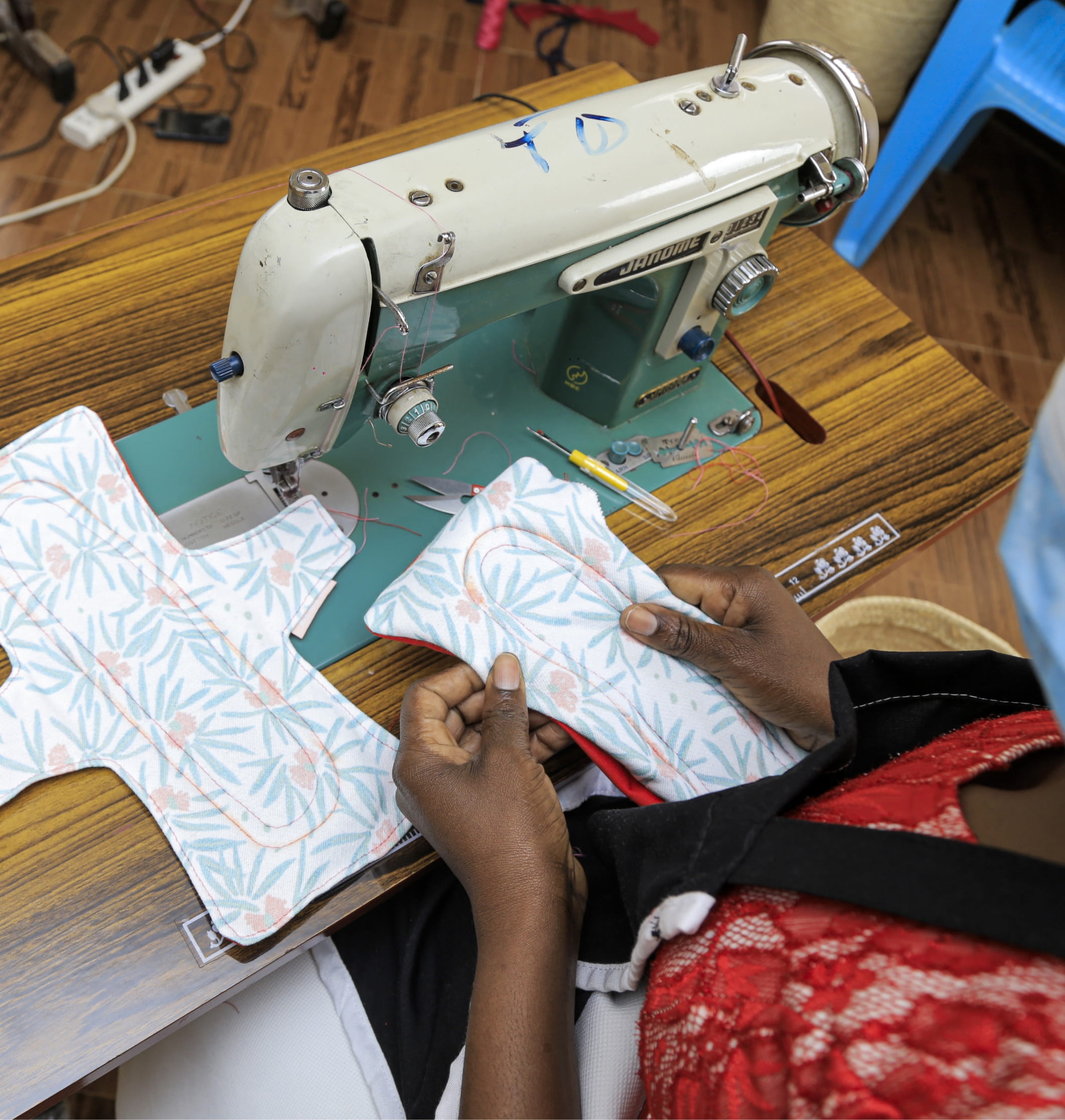 A SHE FOR SHE team member presenting reusable menstrual pads in a classroom.