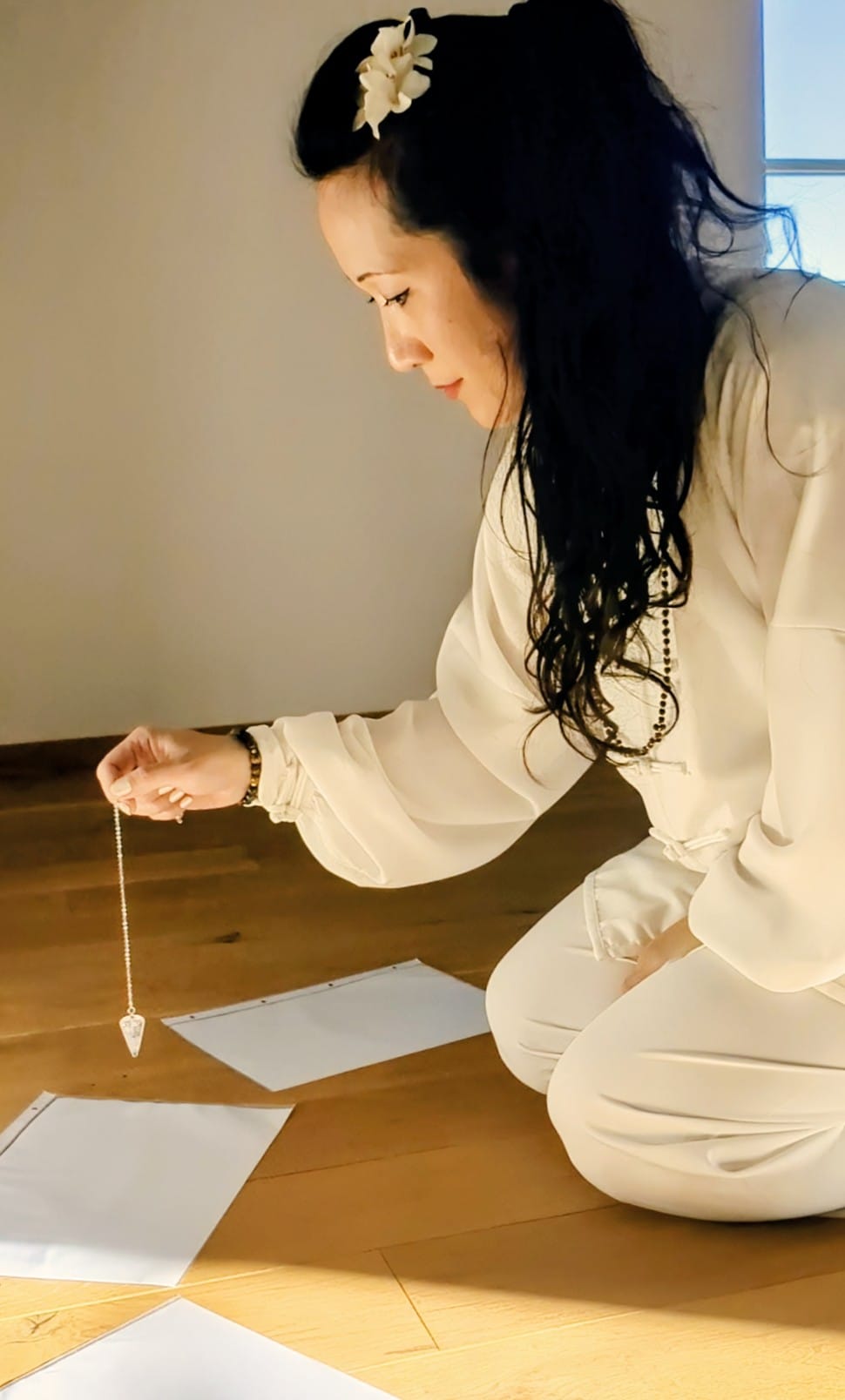 A woman lying down with a towel wrapped around her head, her face glistening with facial oil. Her eyes are closed, and she appears to be enjoying a spa treatment in a peaceful setting.