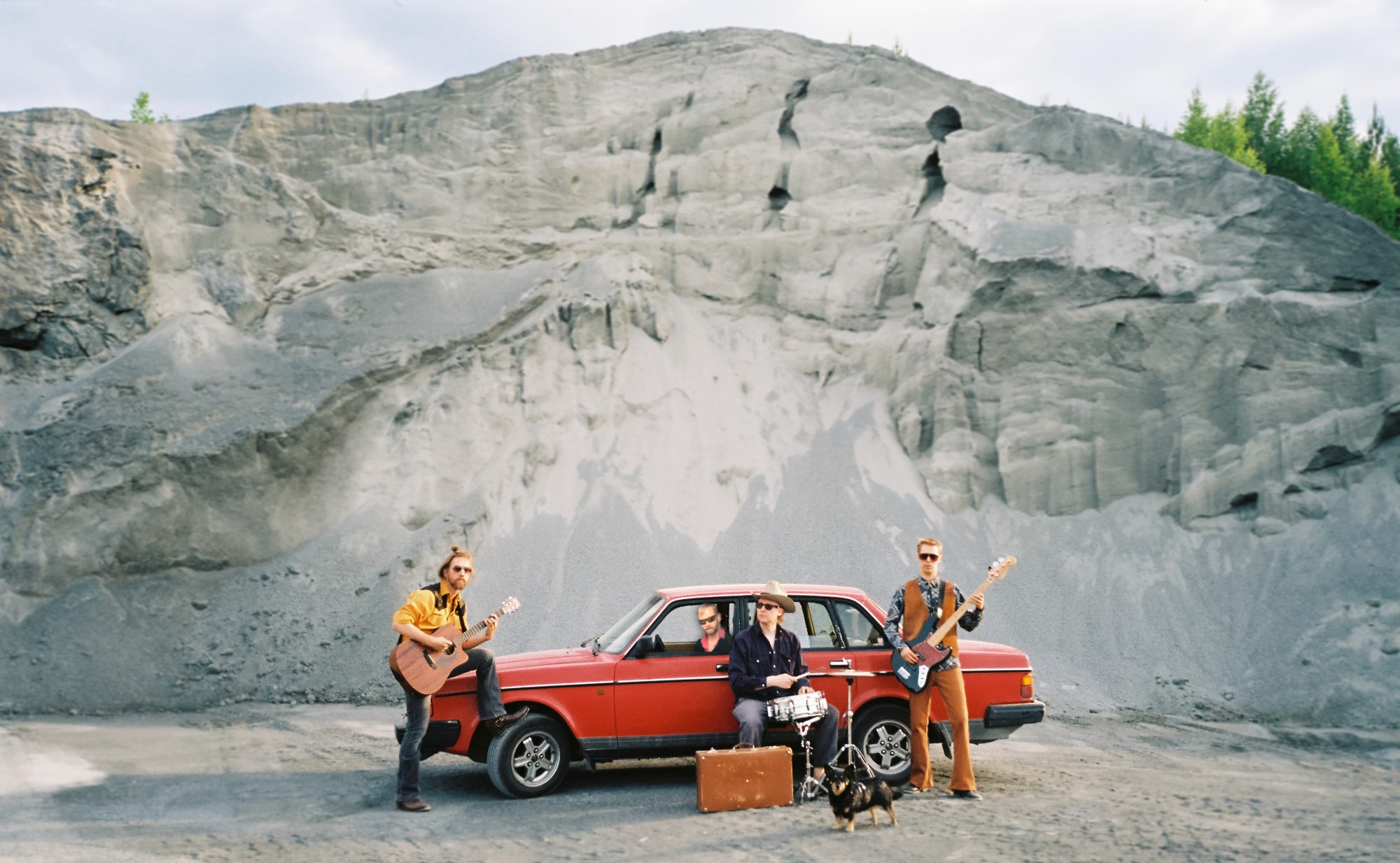 Bleus Brothers posing next to a red Volvo 240