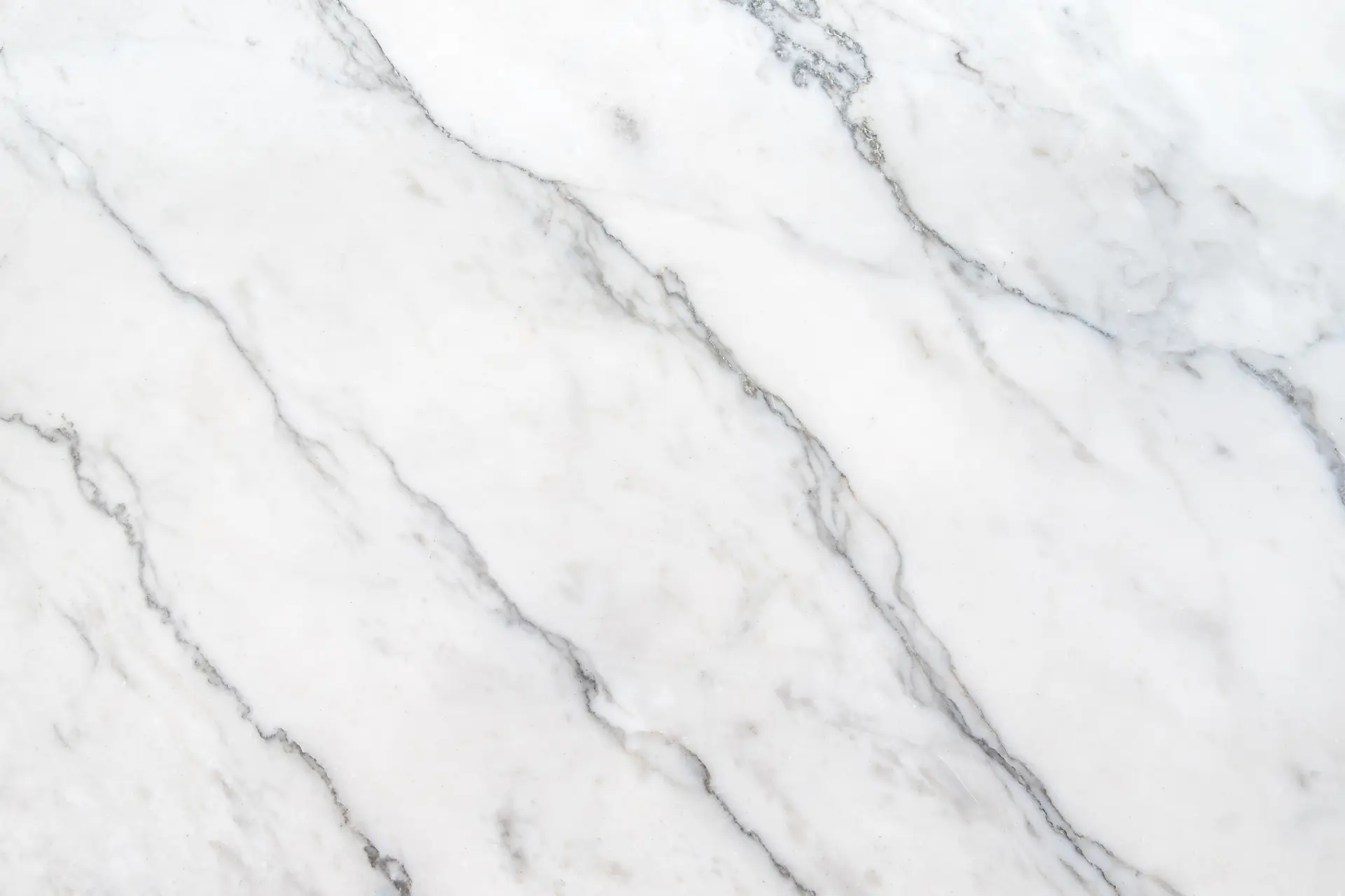 A slab of Cefalù marble from Sicily, showing its creamy white background and subtle gray veining.