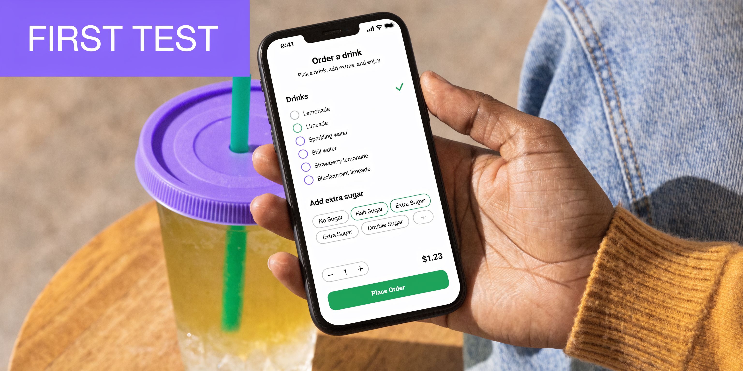 A person holding a smartphone displaying a mobile app interface for ordering drinks on a table.