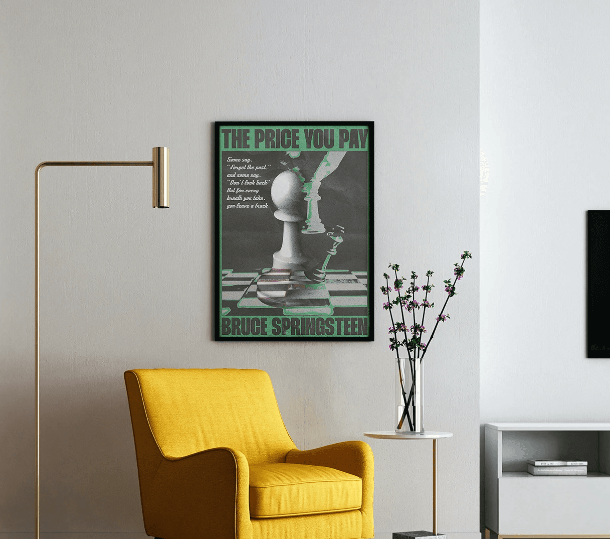 Framed surrealist music poster for Bruce Springsteen hanging in a minimalist interior layout featuring a bright yellow accent armchair.
