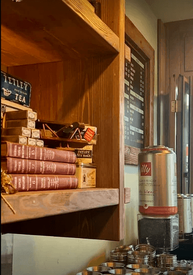 Custom walnut and black timber shelving with traditional Cypriot coffee equipment — boutique café interior design by topos design studio Nicosia
