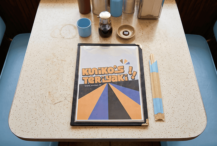 Cover of menu sits face-up on a diner table.