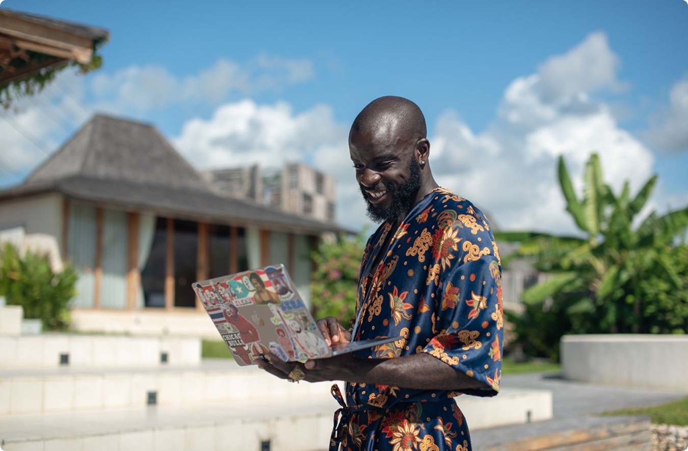 Close-up of a modern building facade featuring vertical wooden panels and black-framed windows, with natural light casting tree shadows on the surfaces.