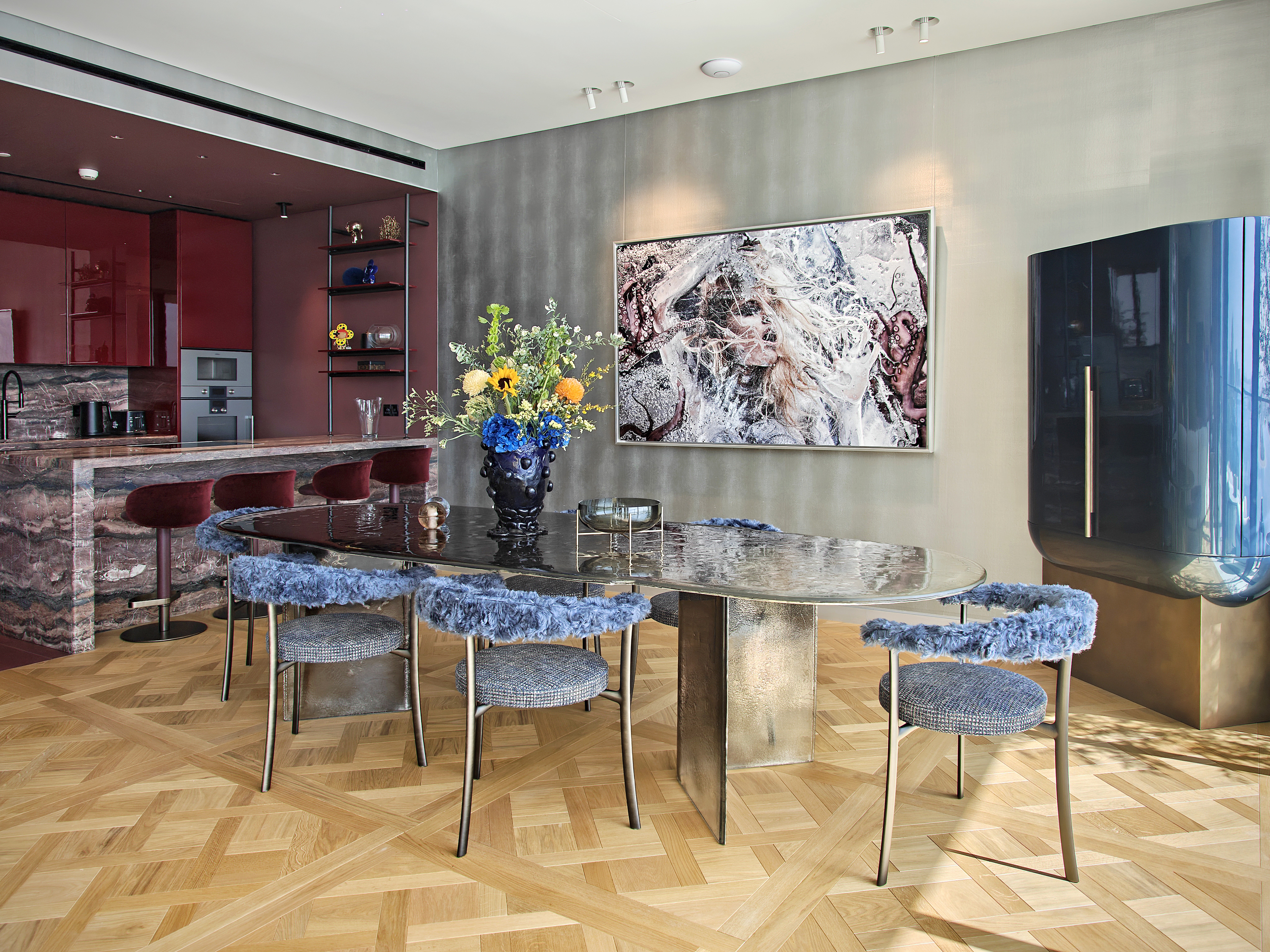 A softly lit hallway with a series of arched doorways, warm-toned walls, and wood flooring leading toward a seating area with neutral furniture.